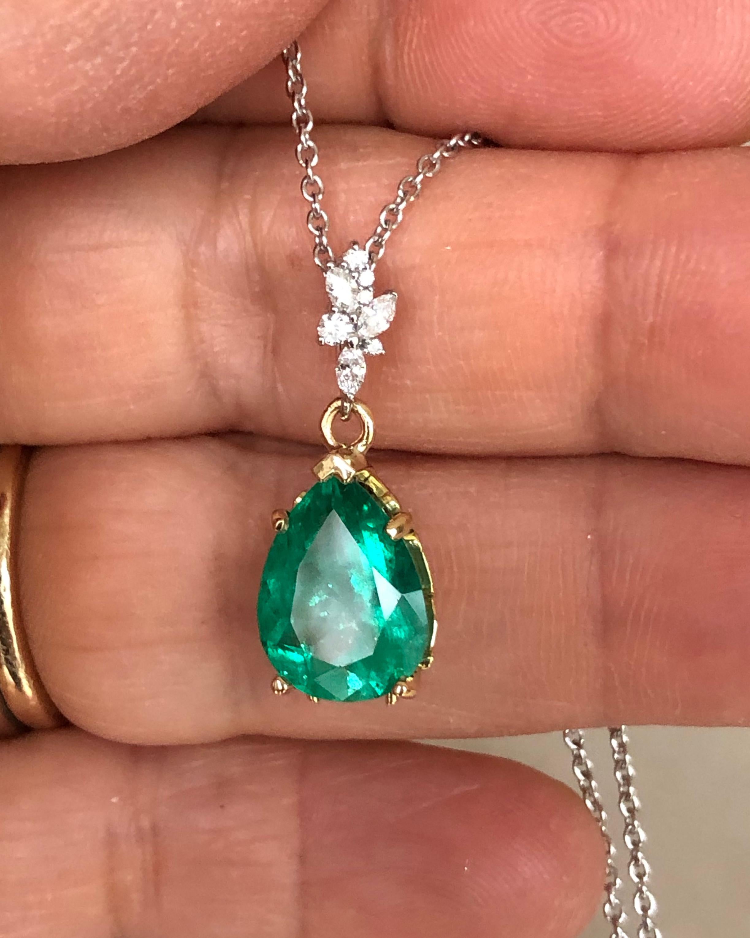 Elegant and Classic Drop Pendant Necklace featuring in the center a fine pear cut Colombian emerald weighing 3.00 carats, minor traditional enhancement. The emerald is set in a beautiful vintage-inspired scroll 18K yellow gold setting suspended by a