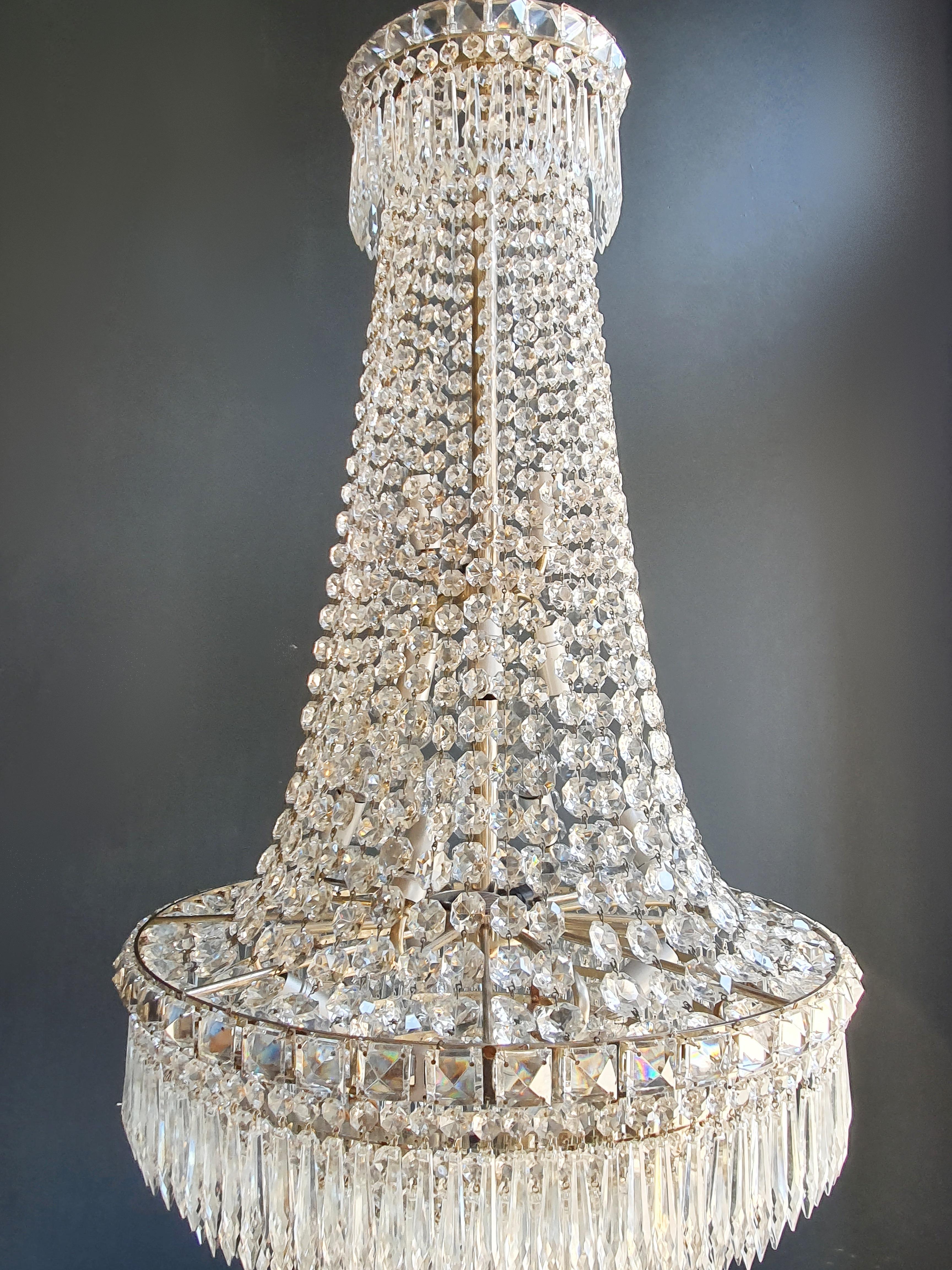 This Italian Empire 14 lights chandelier has a silvered frame. Cut crystal octagonal button chains hang from the top to the bottom of the chandelier all around, where hundreds of icicle cut crystal pendants fall down in a waterfall.

Original