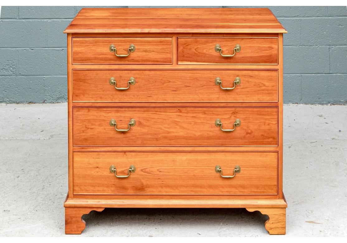 A fine and stylish cabinet in Chippendale style. Cherry chest with two short over three graduated long drawers and plank constructed top and sides. Each drawer with finely carved moldings and solid brass bales. Raised on a carved skirt rail with