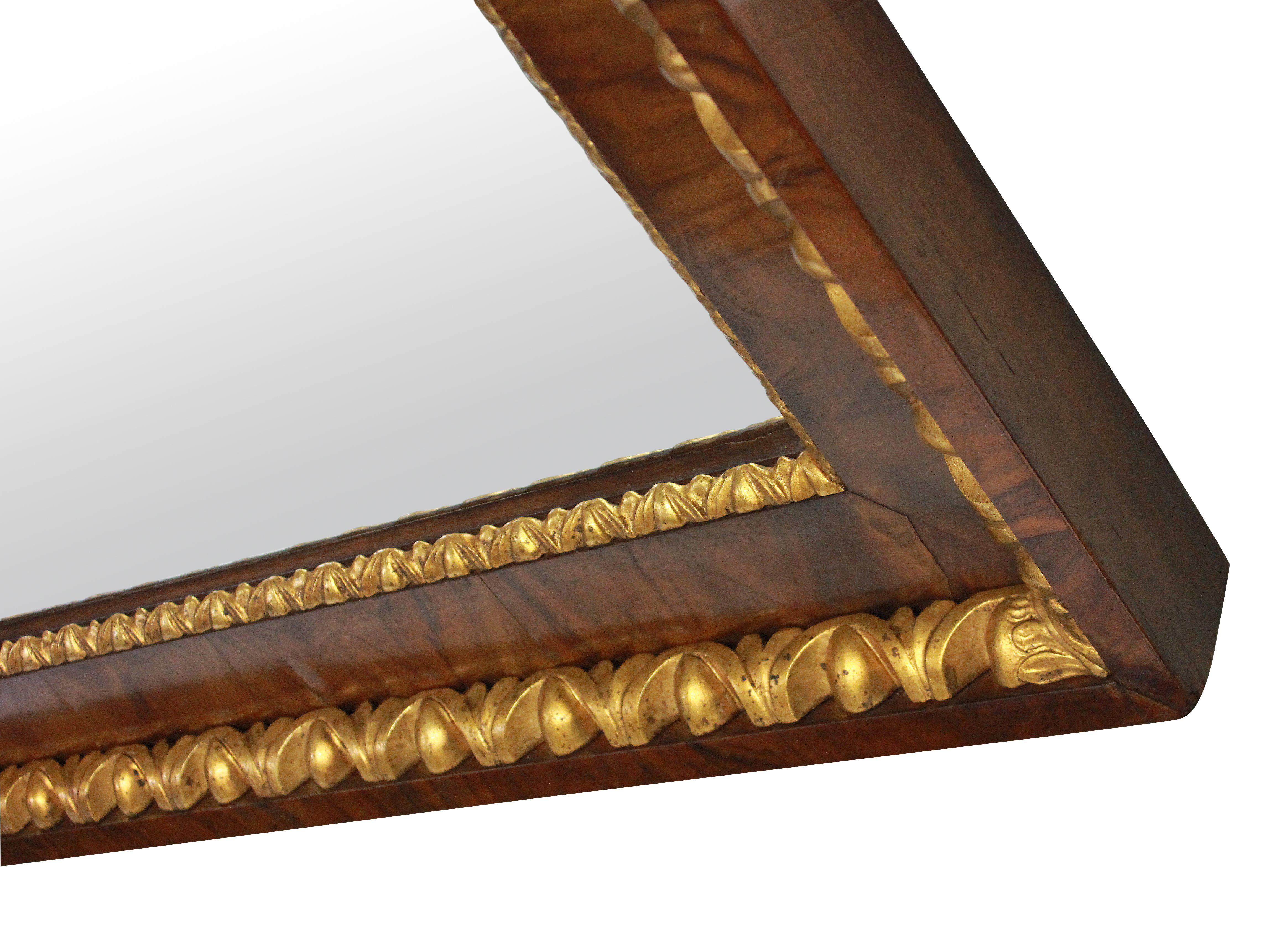 A fine English George II mirror in walnut, with beautifully carved egg and dart water gilded detail. The plate is later.