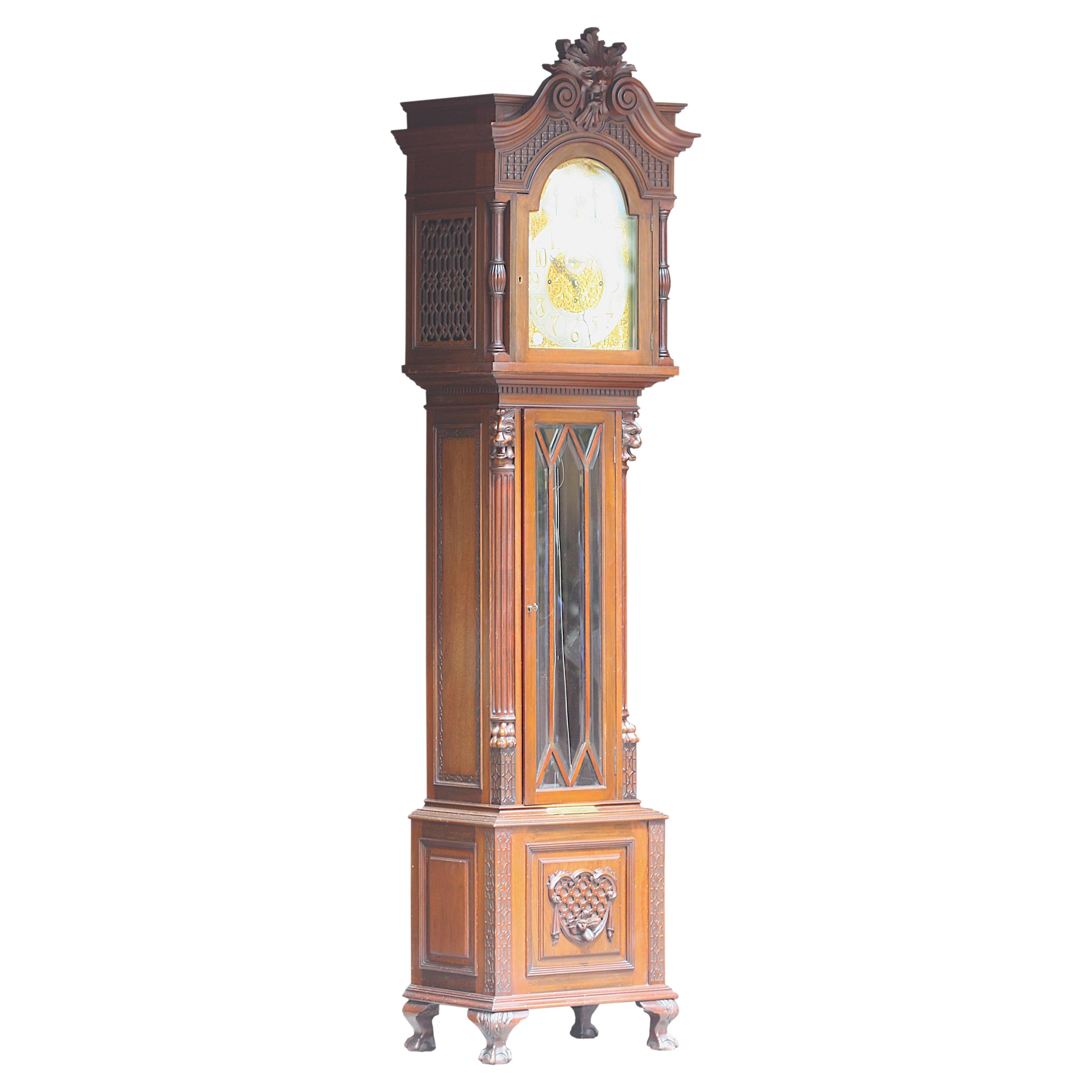 Fine English Renaissance Revival Mahogany Chiming Tall Case Clock.
Circa 1890, Russells Ltd. 
The three-train movement with an arched brass plate, mounted with allover cut-out and raised foliate scrolls, fitted with a Westminster and Whittingham