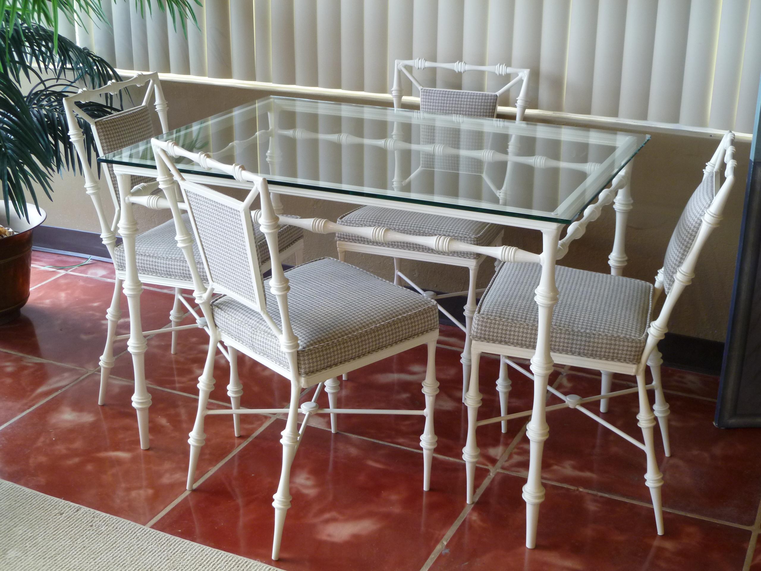 REDUCED FROM $3,500....Great for the outdoors, garden patio or inside dining, this Mid-Century Modern glass top table and chairs are unique and stylish. Featuring four chairs and a table with a stylized take on chinoiserie and faux bamboo. The