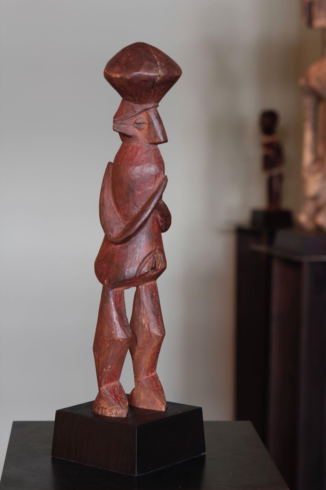 This beautifully carved 'Biteki' figure, from the Yaka culture in the Democratic Republic of the Congo, depicts a female crowned with a large, abstracted coiffure. The figure exhibits a wonderful sculptural form with Cubist-like legs, and a sense of