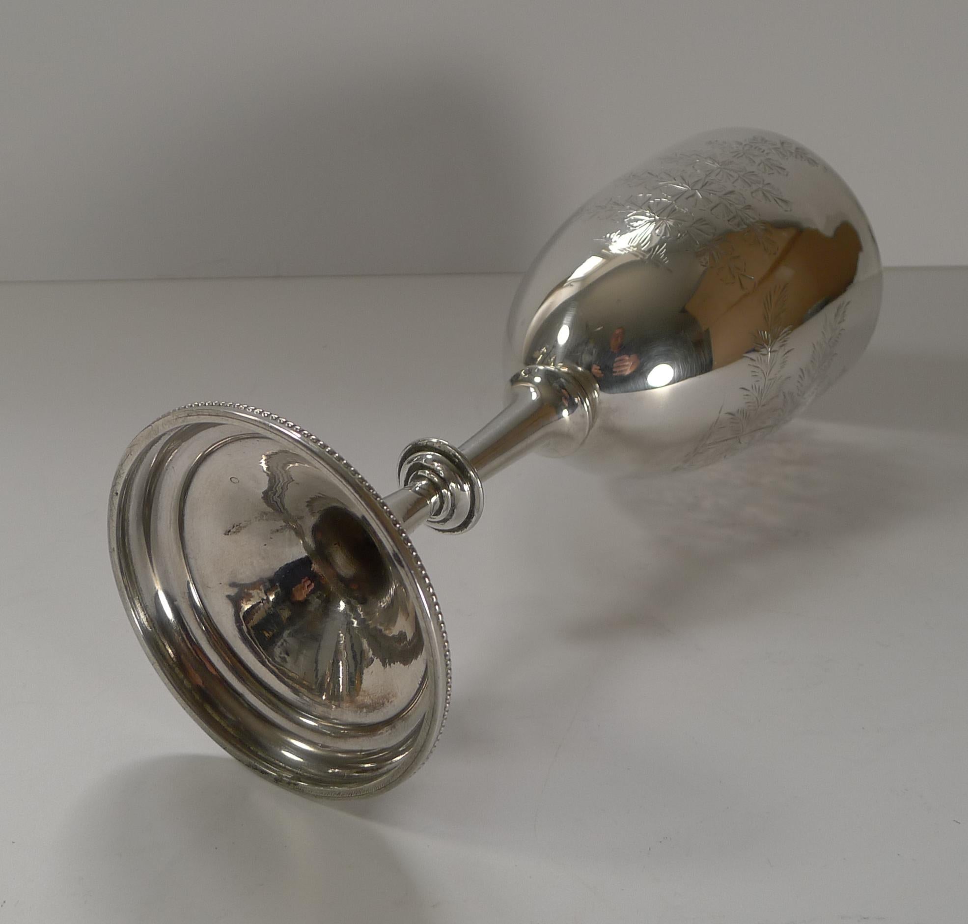 A terrific large victorian sterling silver goblet or trophy beautifully engraved with Fern engravings surrounding a vacant cartouche (without personal engravings).

Fully hallmarked for London 1883 together with makers mark for the well renowned