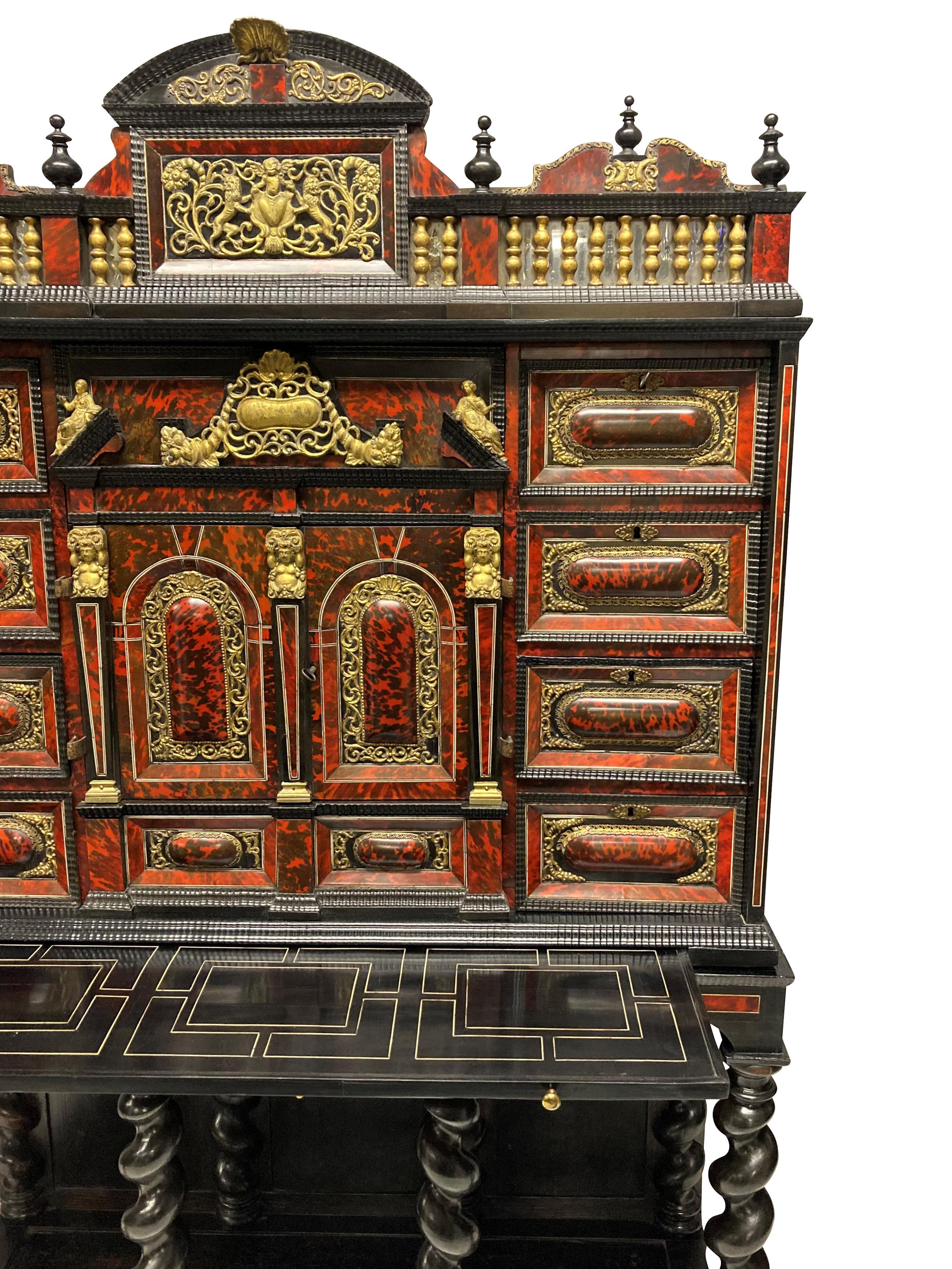 A rare and of fine quality, late XVII Century Flemish European ormolu mounted ebony and red tortoiseshell cabinet on stand, of architectural form, crowned with an architectural, galleried pediment. Below: two central finely decorated doors opening