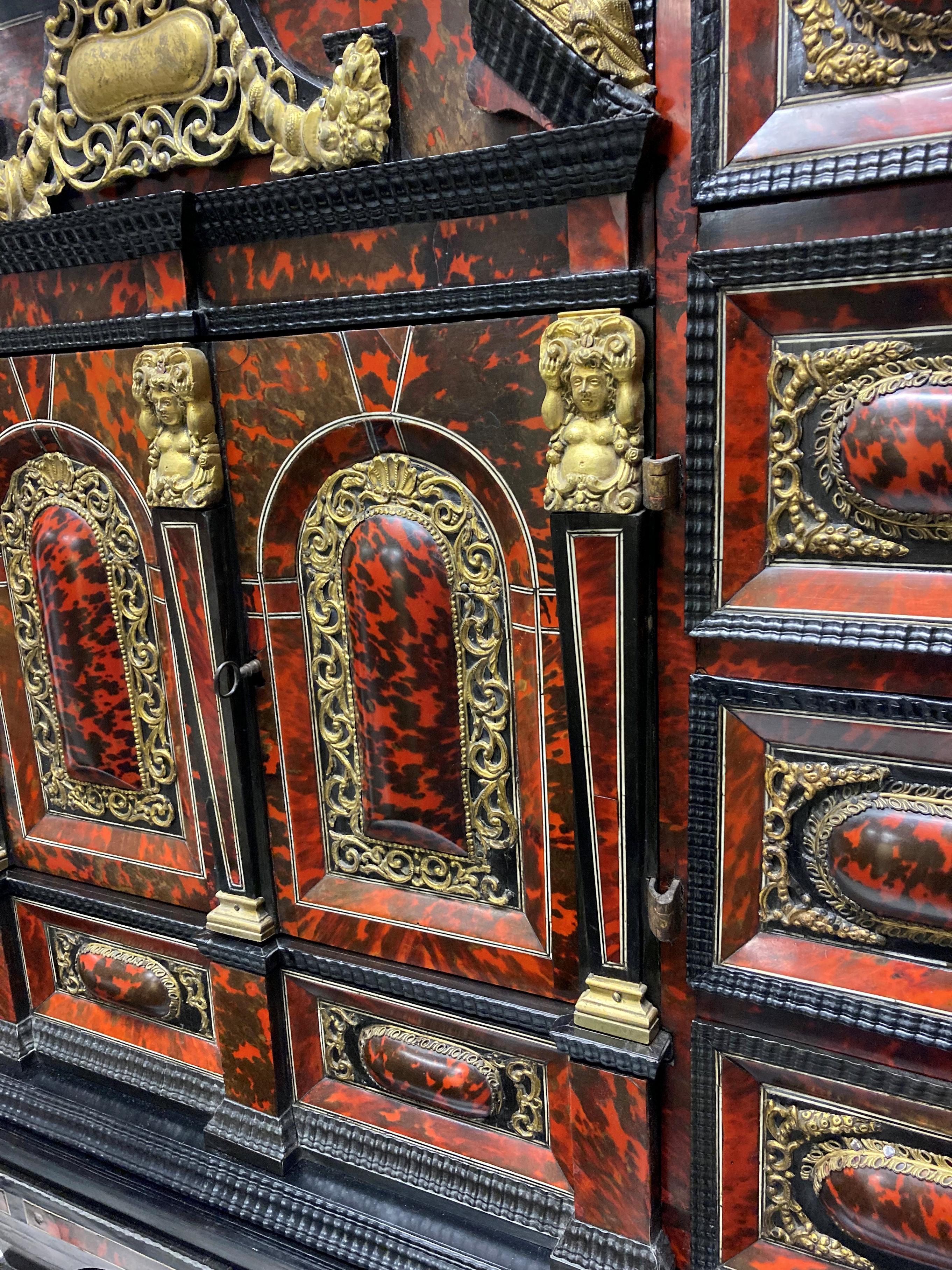 A rare and of fine quality, late XVII Century Flemish European ormolu mounted ebony and red tortoiseshell cabinet on stand, of architectural form, crowned with an architectural, galleried pediment. Below: two central finely decorated doors opening