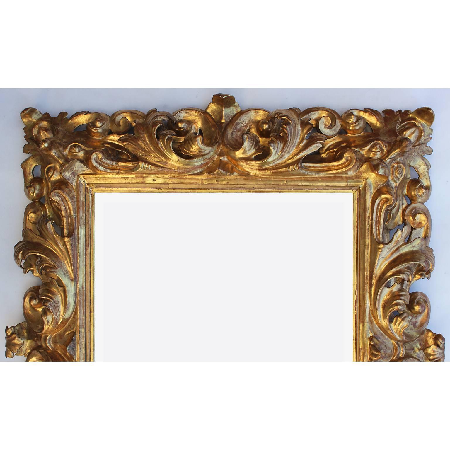 A very Fine Italian 19th century Baroque Revival style Florentine giltwood carved figural mirror frame, with carvings of allegorical masks on each corner and scrolled acanthus borders and centred with a bevelled mirror plate. All gilt is original,