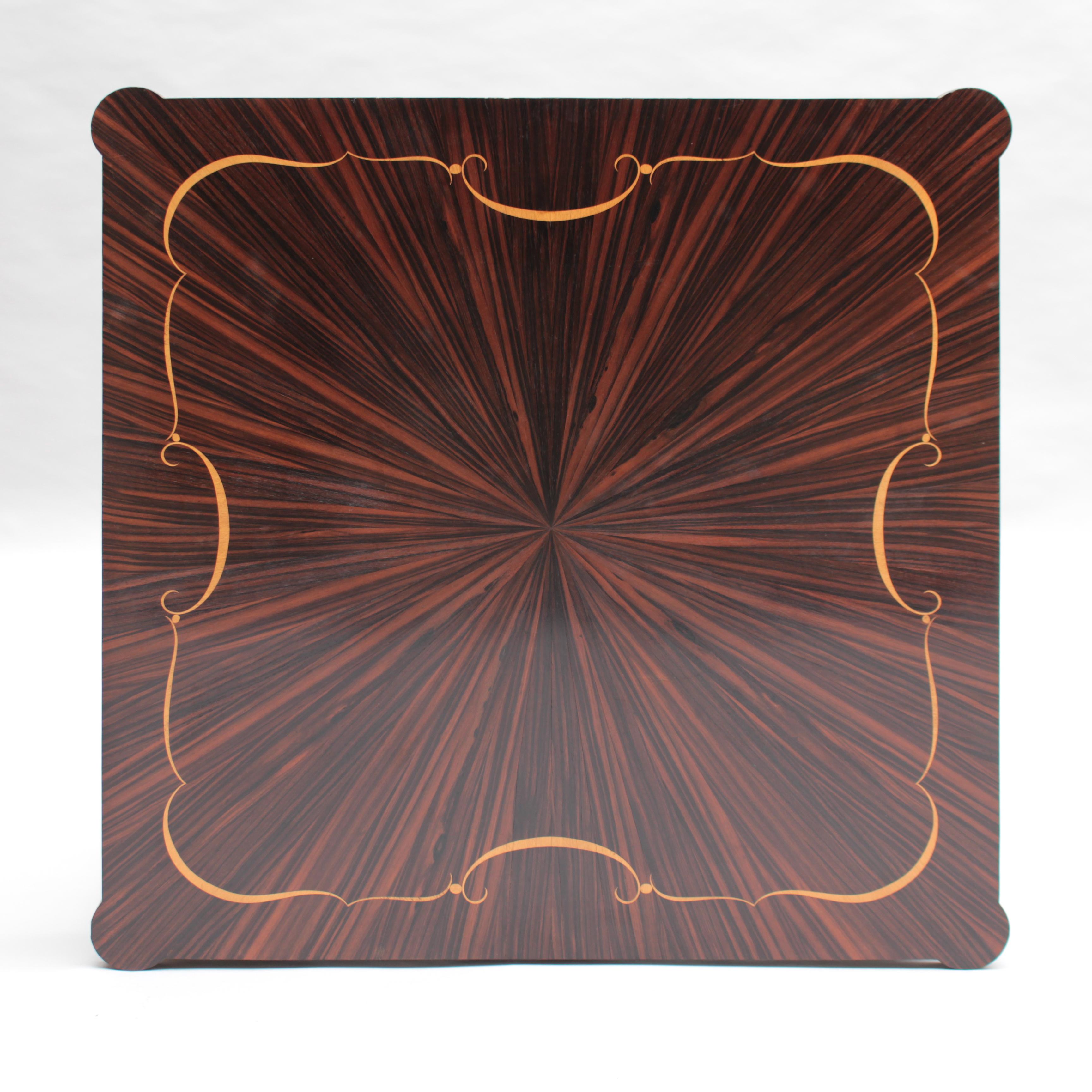 Table de jeu/guidon de style Art Déco, avec un plateau en ébène de Macassar et marqueterie de sycomore, et des étoiles en laiton.
Les pieds sont en faux ébène de Macassar.