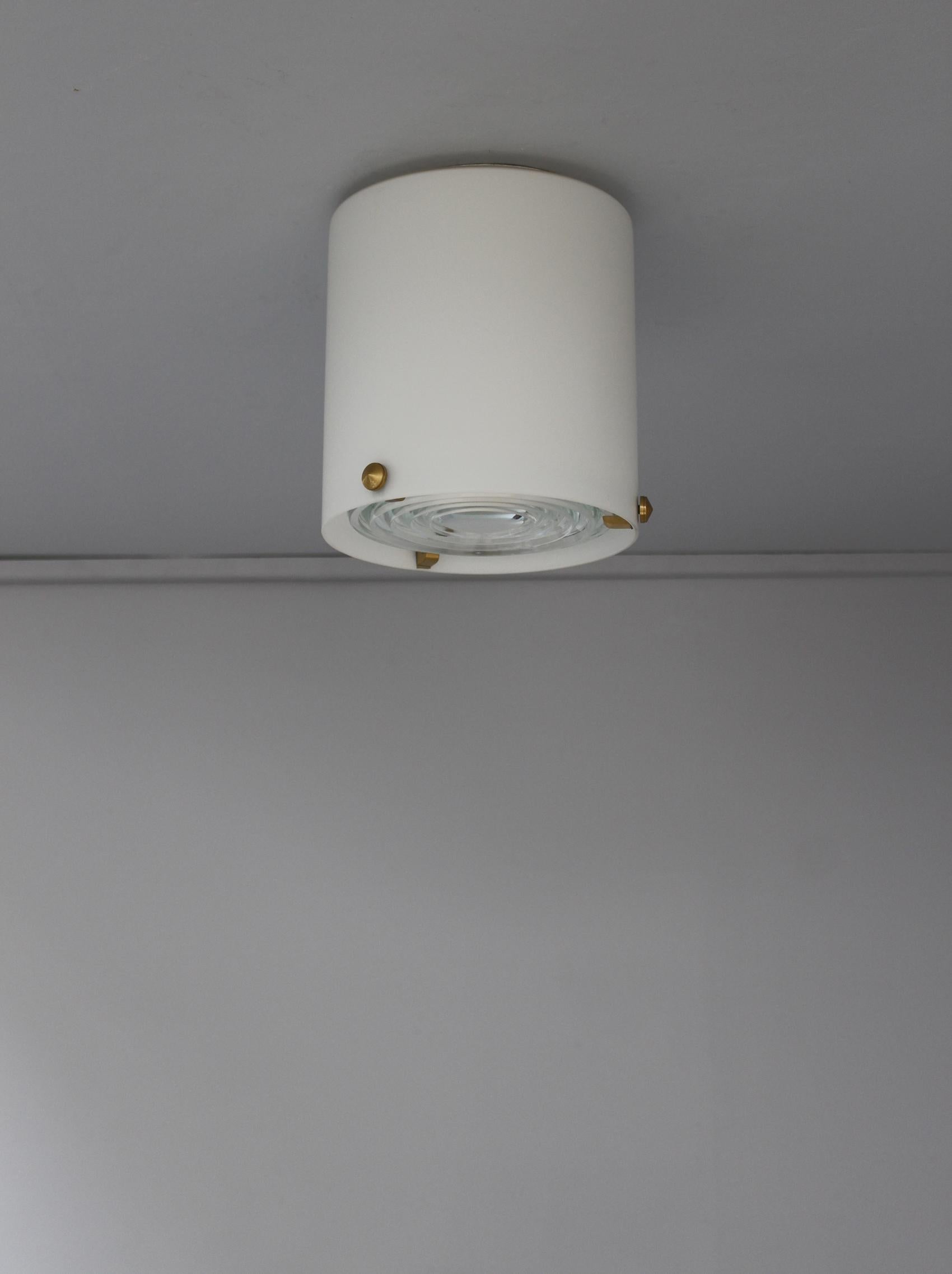 Jean Perzel - A fine French midcentury cylinder-shaped flush mounts / ceiling lights in enameled glass with three brass studs that support a prismatic glass lens.