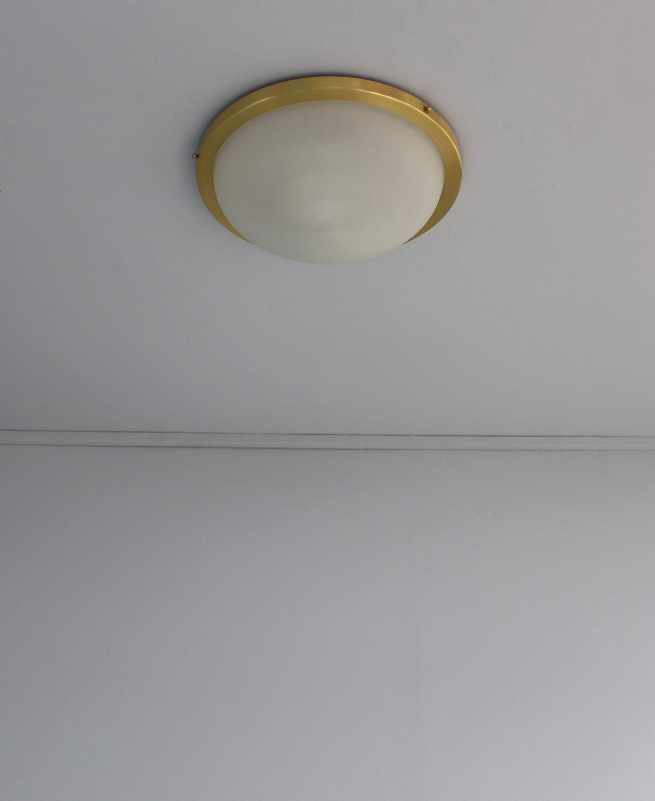 With a satin brushed circular brass structure that holds a fluted frosted glass bowl diffuser.
Signed.