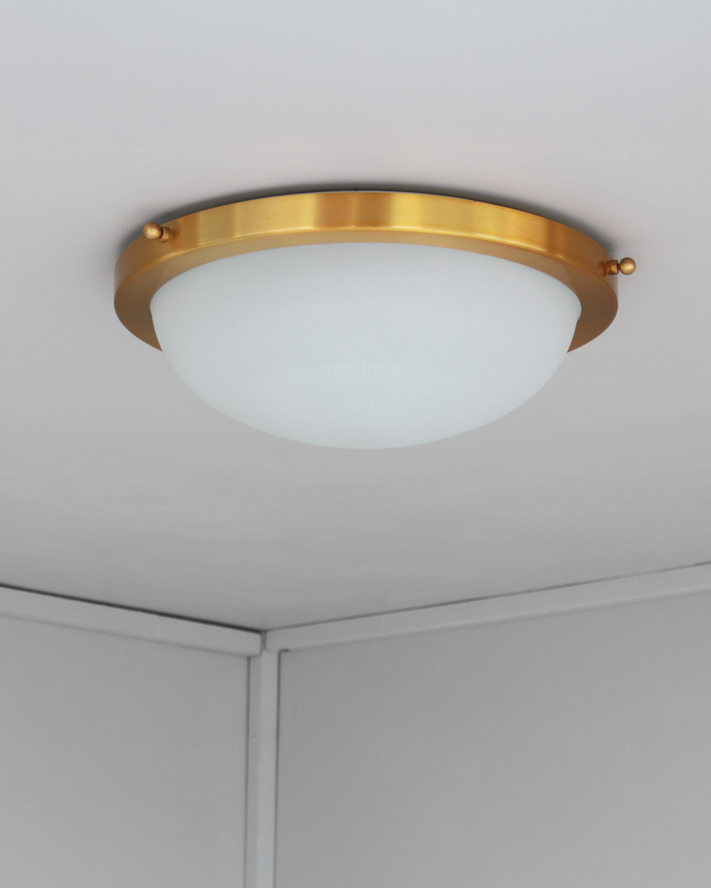 Atelier Jean Perzel - A fine French Art Deco flush mount ceiling fixture or wall light with a fluted round and frosted glass shade supported by a brass mount.
