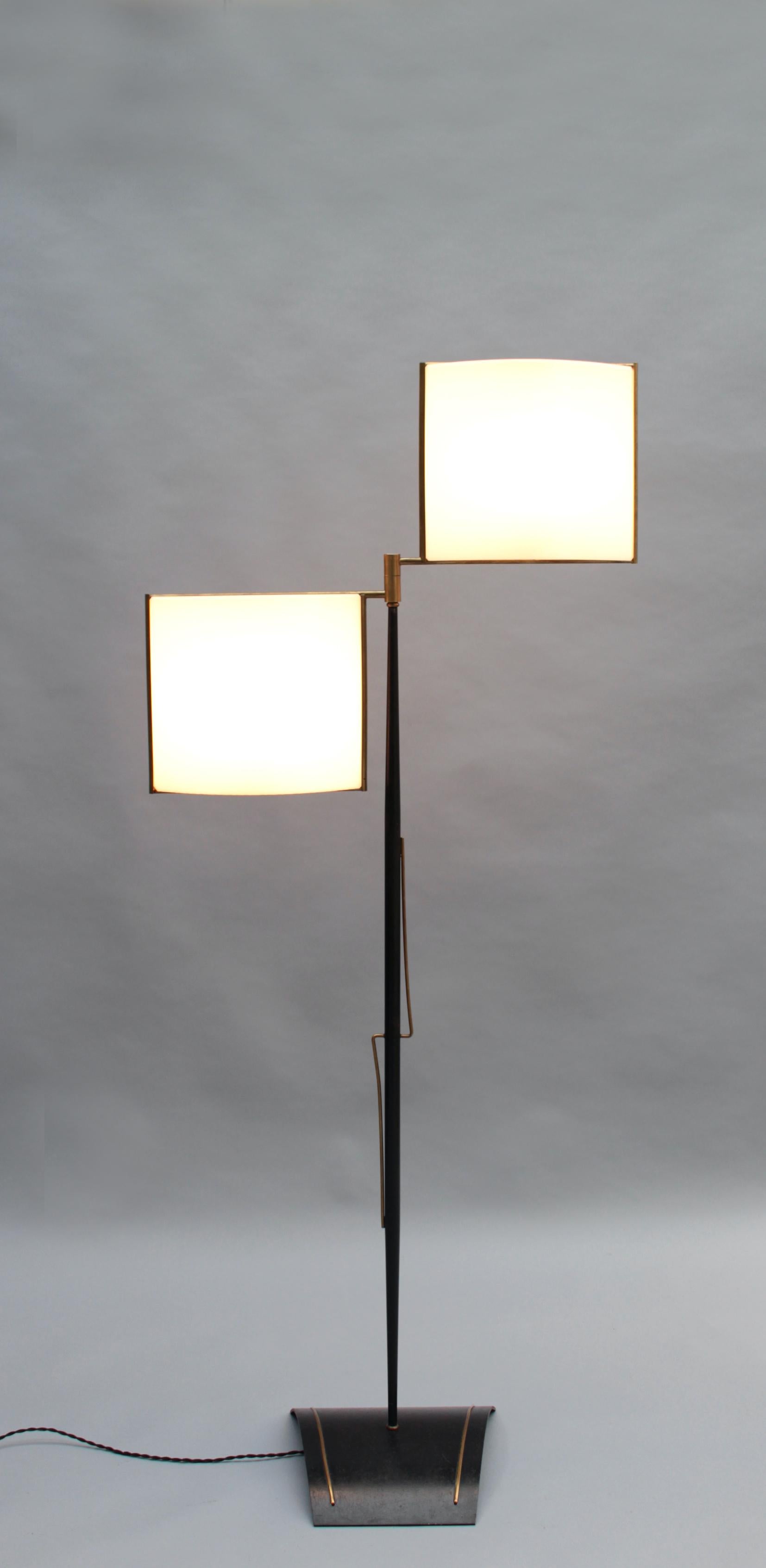 A fine French Mid-Century floor lamp by Lunel with a black lacquered and brass frame that supports two original Perspex shades.

