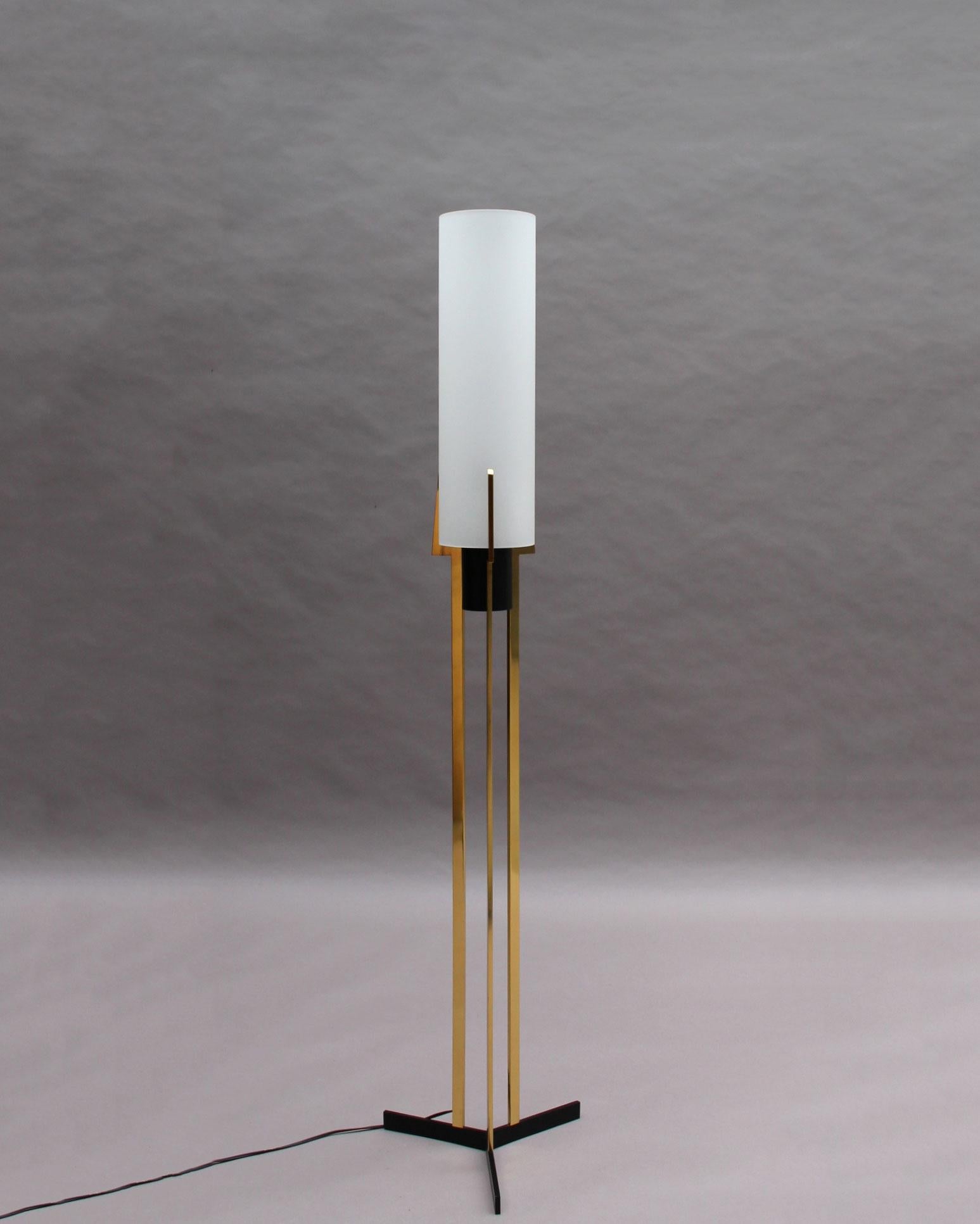 Rare floor lamp by Arlus with a blackened metal and brass tripod base that supports a cylindrical frosted glass diffuser.