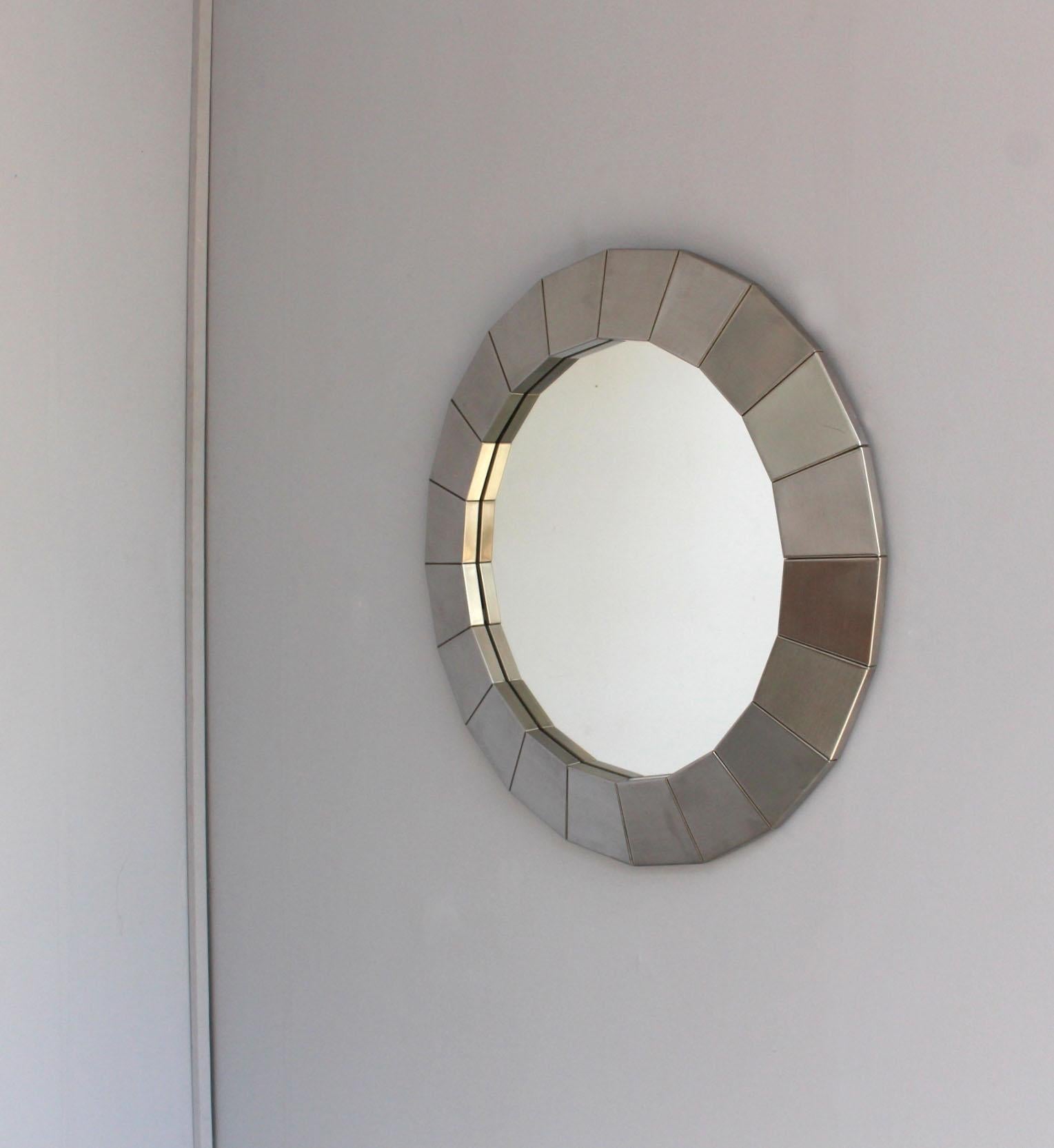 A fine French 1970s round faceted polished stainless steel framed mirror.