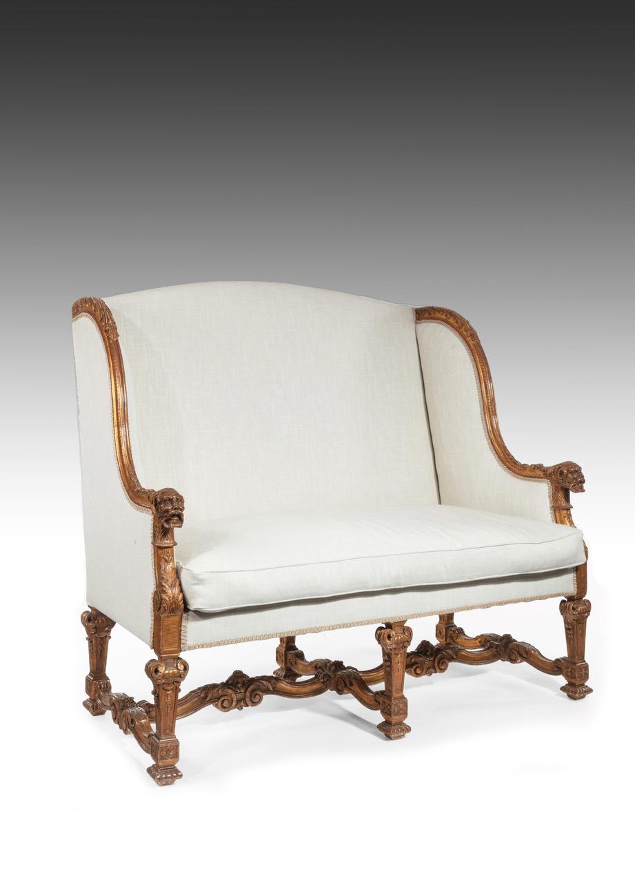 A very finely carved mid-19th century original giltwood French Louis XIV style sofa upholstered in Voyage linen, circa 1860

The rectangular back with arched top having acanthus leaf carved giltwood scrolling arms terminating in finely carved male