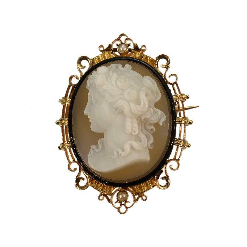 A large fine French antique brooch pendant in 18 karat rose gold, French control mark, featuring a quality antique cameo adorned with half seed pearls and black enamel depicting a woman head with wreath and flowers. Cameo dimensions 0.98 inch x 1.30
