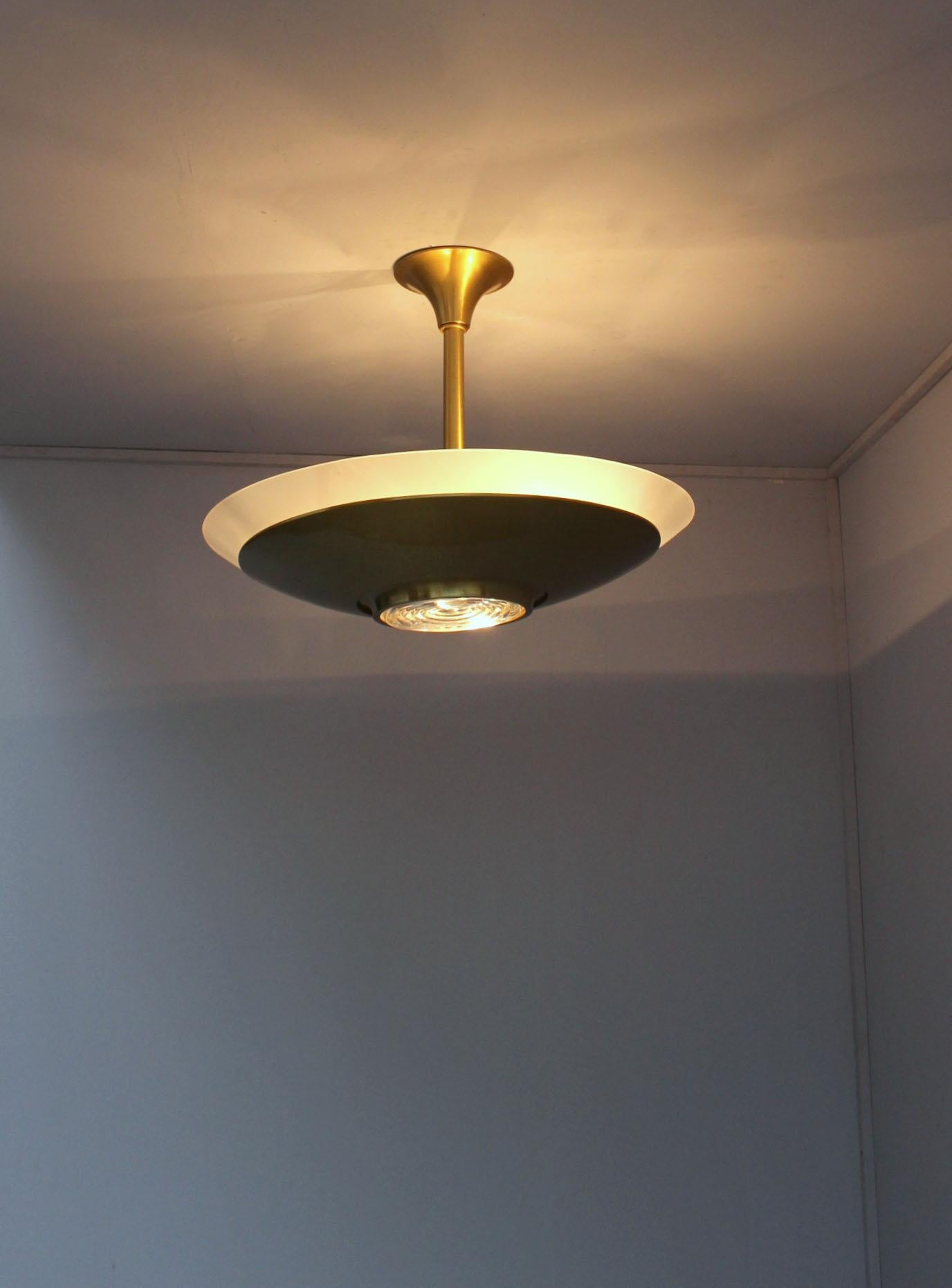 A fine French Art Deco chandelier by Jean Perzel with a convex frosted glass diffuser sitting on a brass bowl and a center prismatic glass lens.