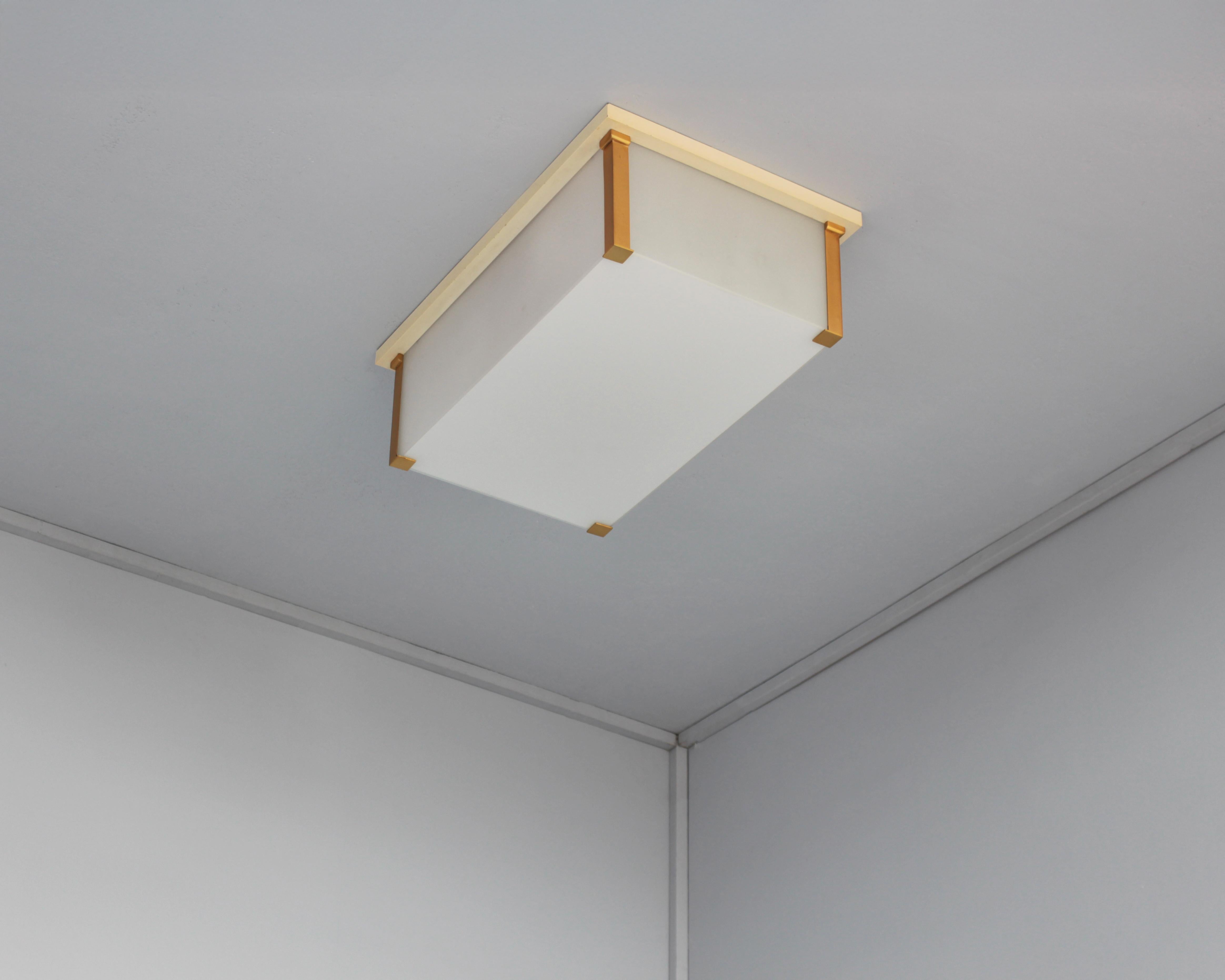 Jean Perzel : Un plafonnier rectangulaire Art Déco français avec un cadre peint au pinceau et en bronze qui supporte les diffuseurs latéraux en verre, et un diffuseur inférieur en verre émaillé blanc qui est amovible pour changer les ampoules.
Signé