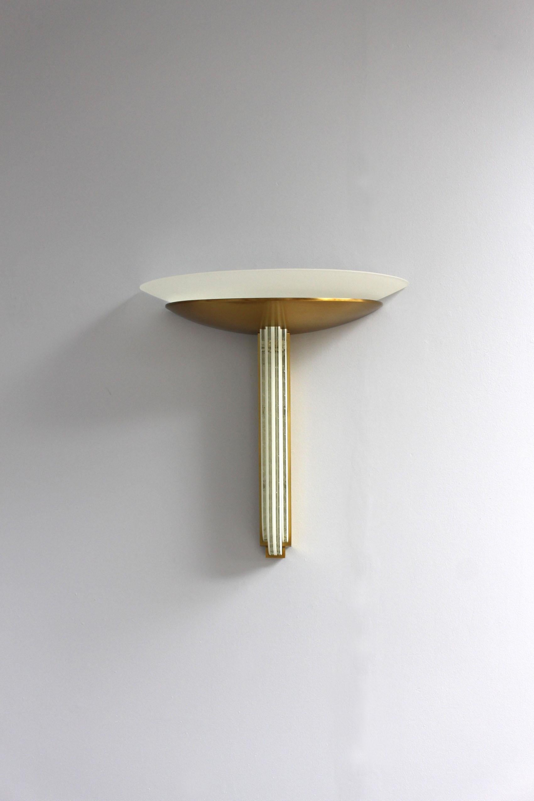 Jean Perzel - Una raffinata applique francese Art Déco realizzata con lastre di vetro a taglio diamantato verticali delineate da una montatura in bronzo e da una coppa in bronzo che sostiene un diffusore in vetro smerigliato bianco.
Questa applique
