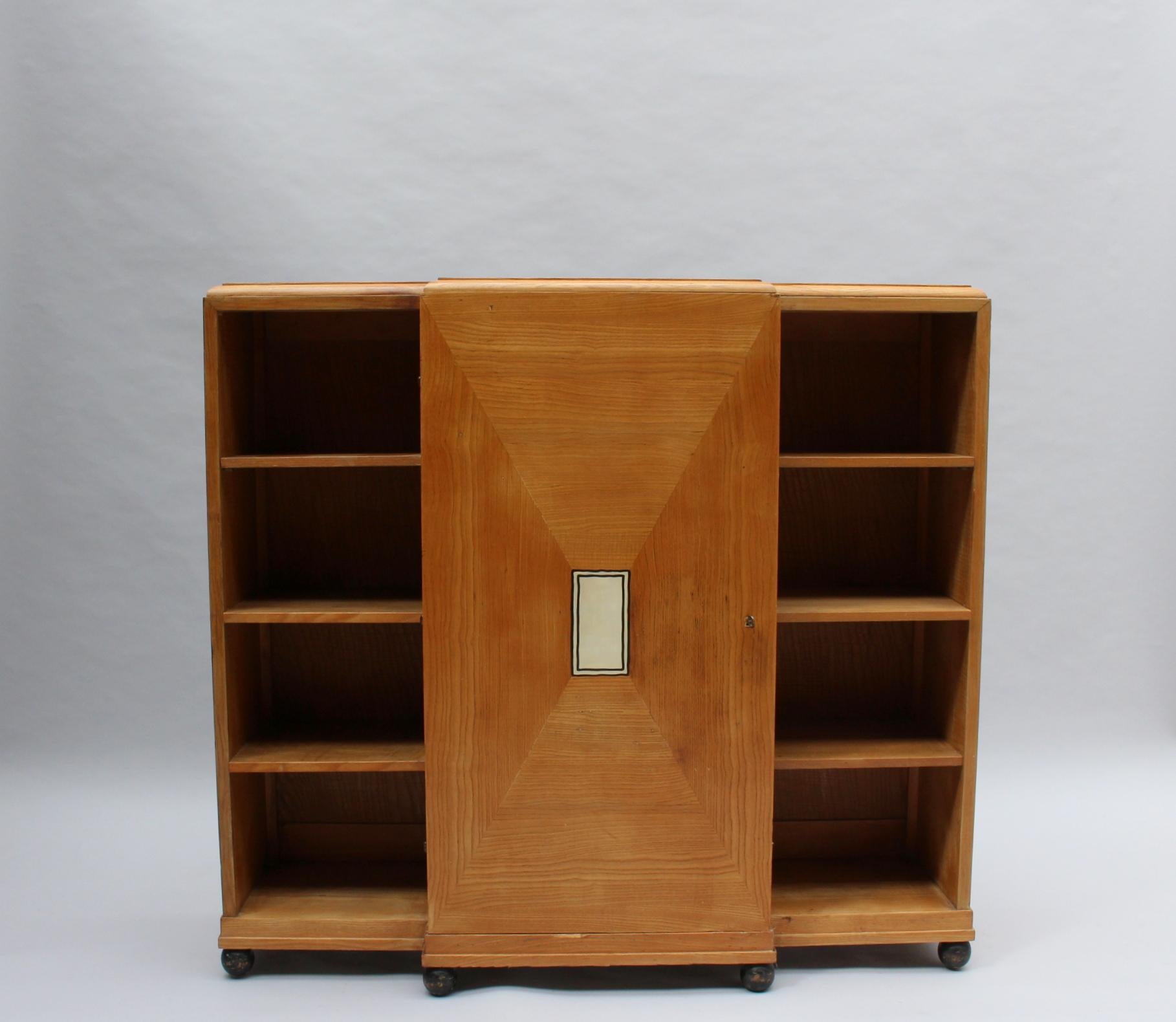 With a central wood and bone marquetry door, two inside drawers and brass hardware.