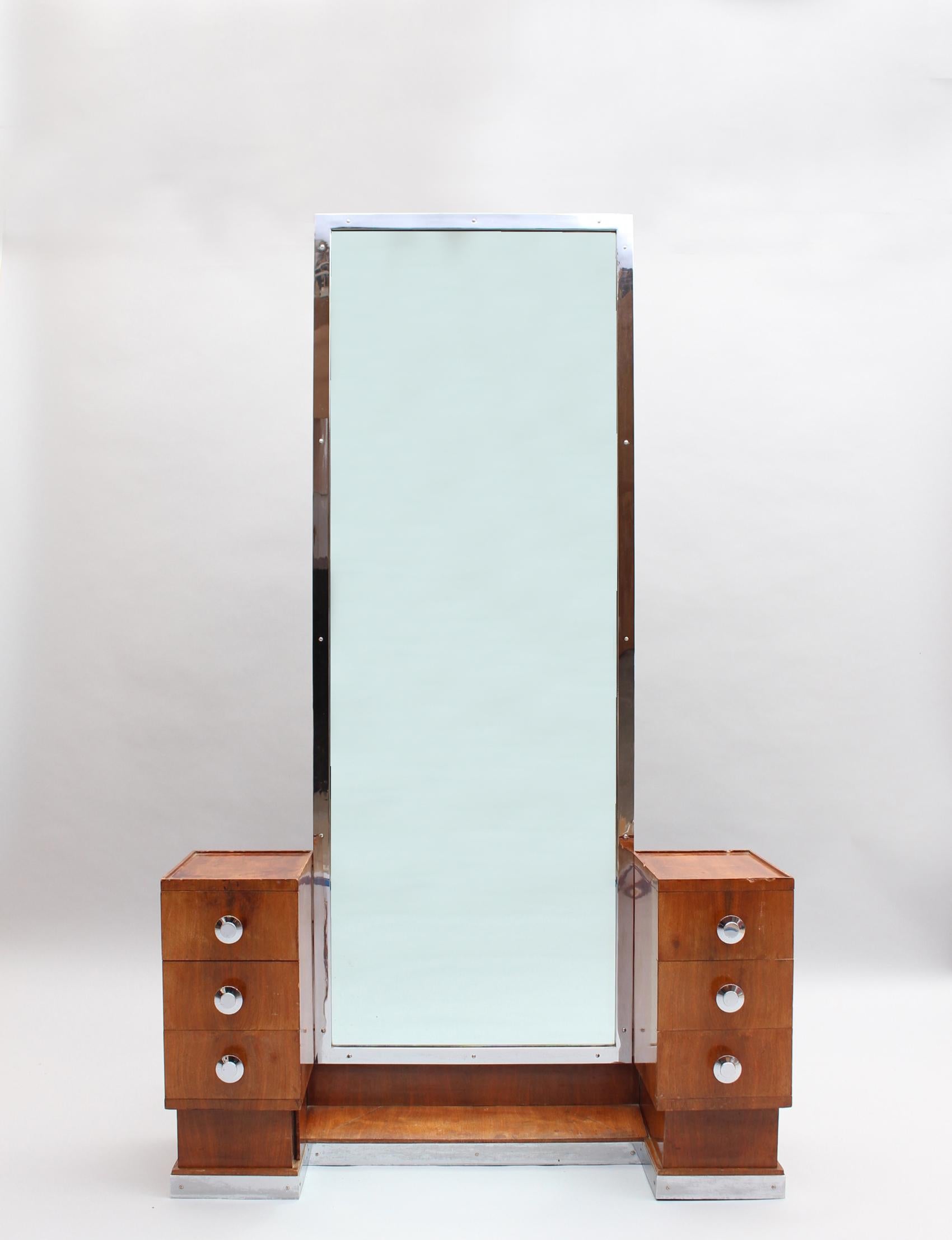 A fine French 1930s wooden psyche / vanity with six drawers, one secret drawer, a chrome framed mirror, and chrome baseboard and knobs. The back of the piece is also veneered so it could be placed in the middle of a room.