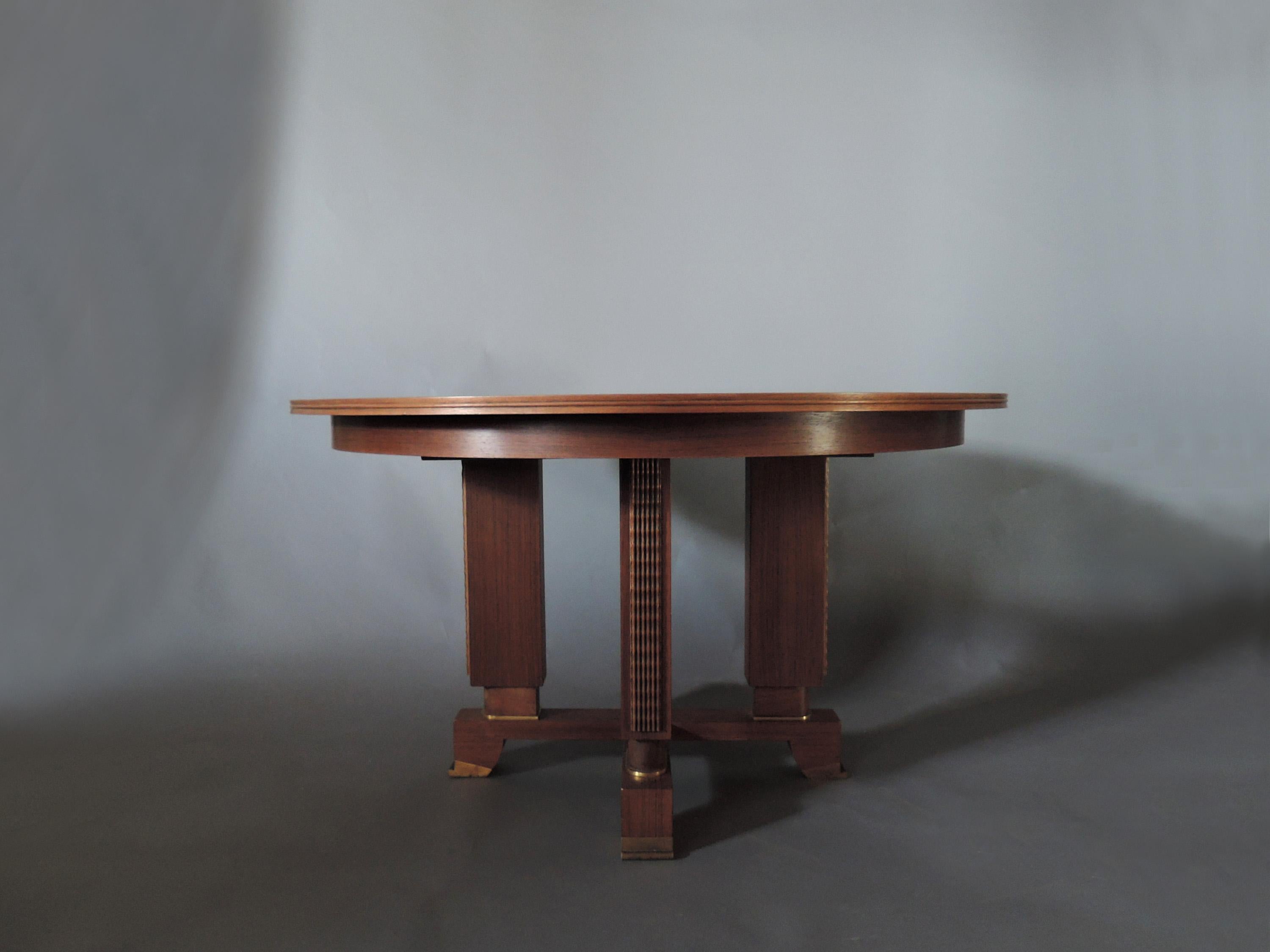 Jules Leleu : Une belle table de salle à manger Art Déco en palissandre avec une base à 4 pieds et des détails en bronze.
2 feuilles centrales originales en bois brut, la longueur avec les feuilles est de 89 3/4