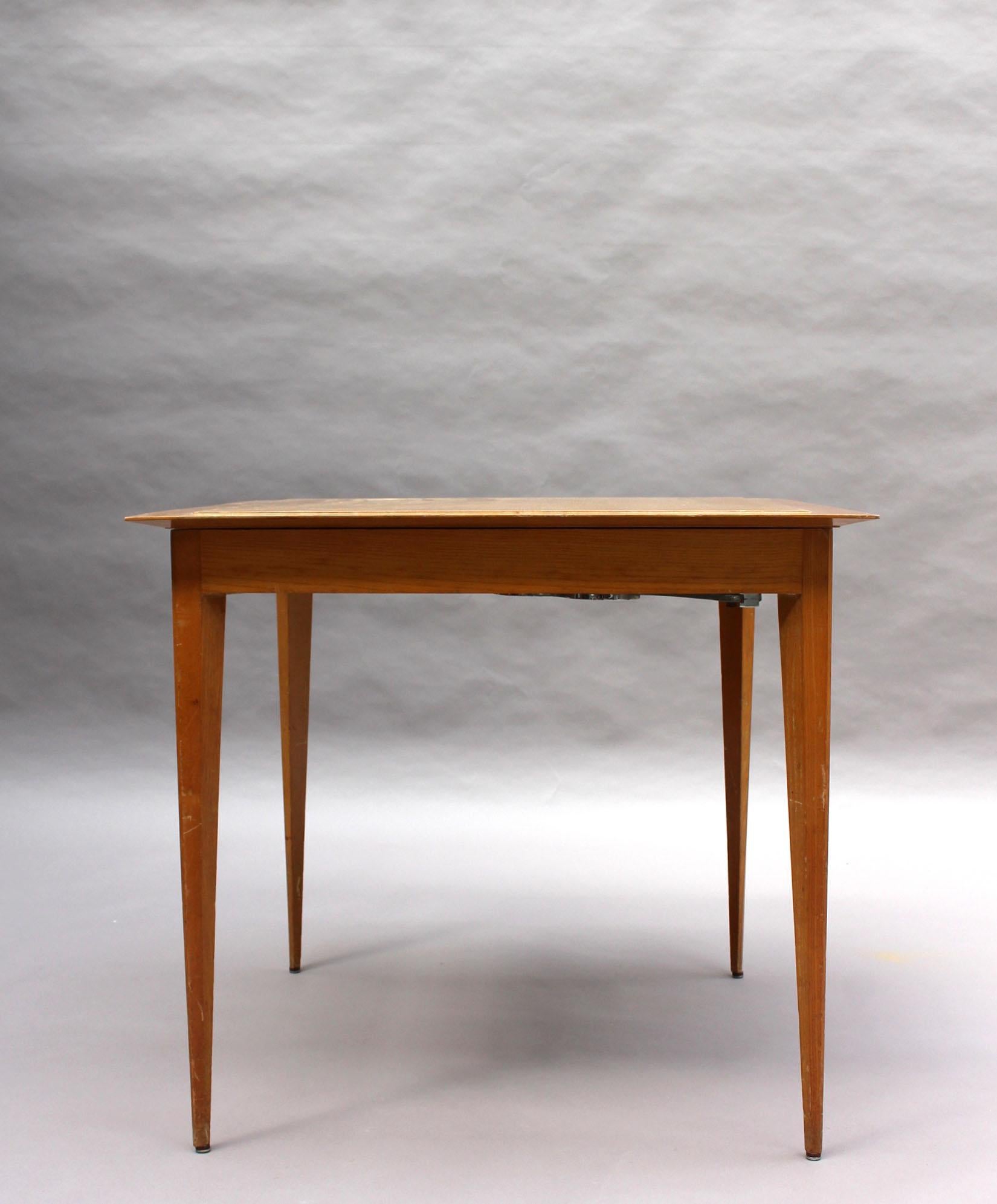 Rinck - established in 1841 and directed by Maurice Rinck in the Art Deco / mid-century period.
A fine game / tea table in elm with a reversible top (wood on one side and felt on the other) with four tapered legs and chrome cup / ashtray