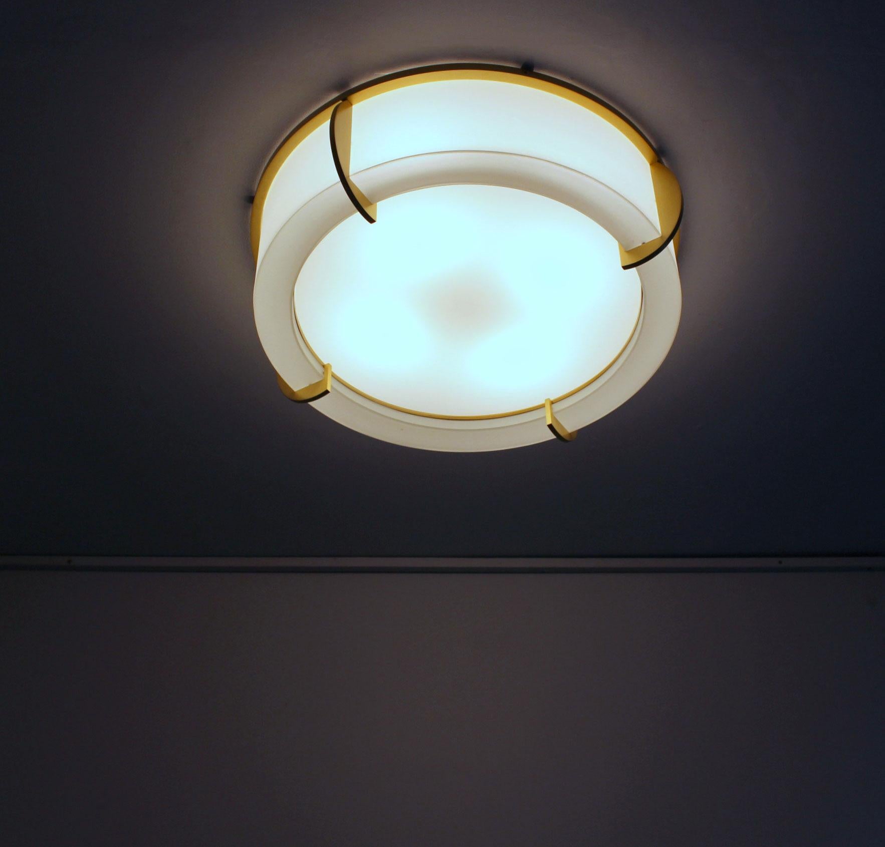 Mounted on a bronze crown-shaped frame that holds the frosted glass diffusers. The round white horizontal laminated white glass diffusers is easily removable in order to change the bulbs.

 