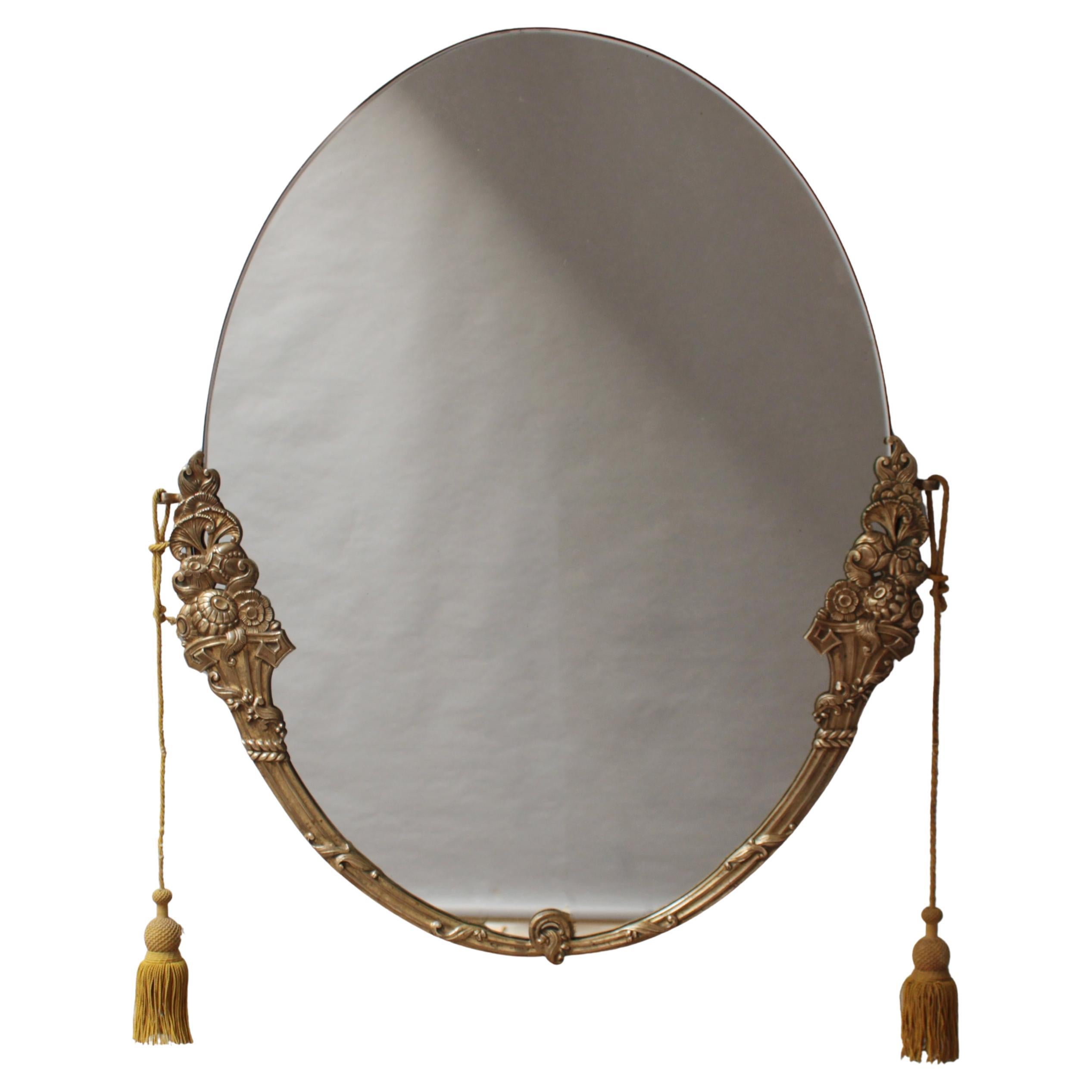 Rococo style, the semi-oval solid brass frame is adorned with floral decorations, and the original passementerie / tassel.