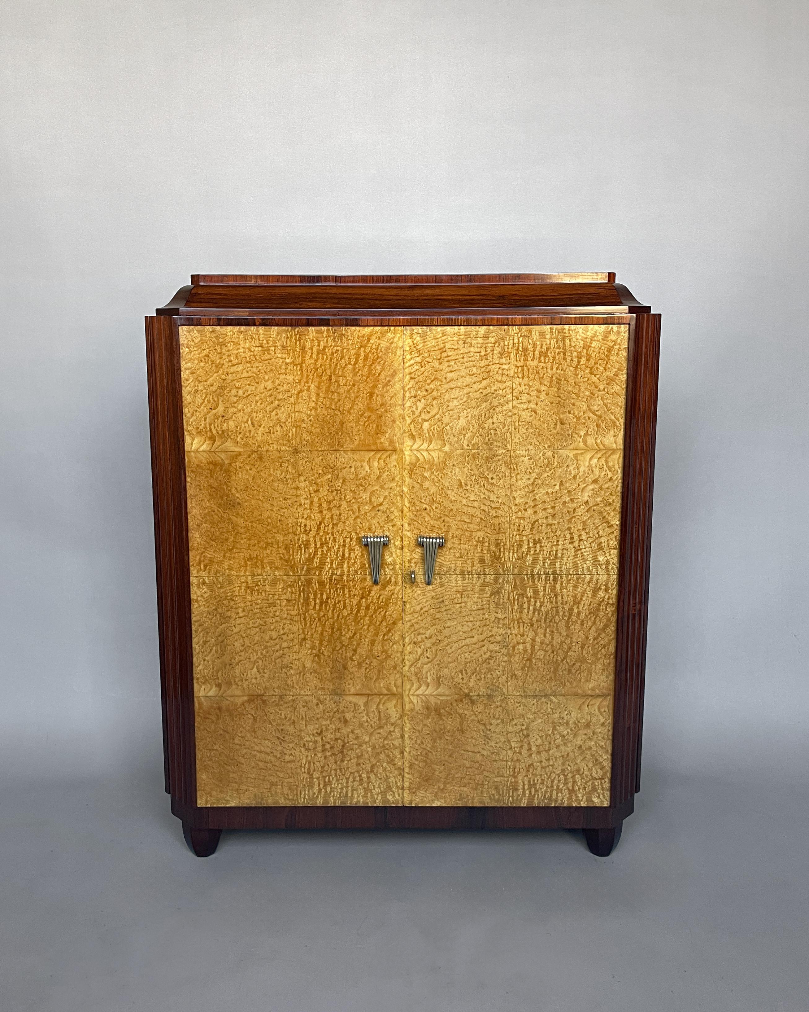 An elegant French 1930s rosewood and elm burl two door cabinet with refined bronze details.

