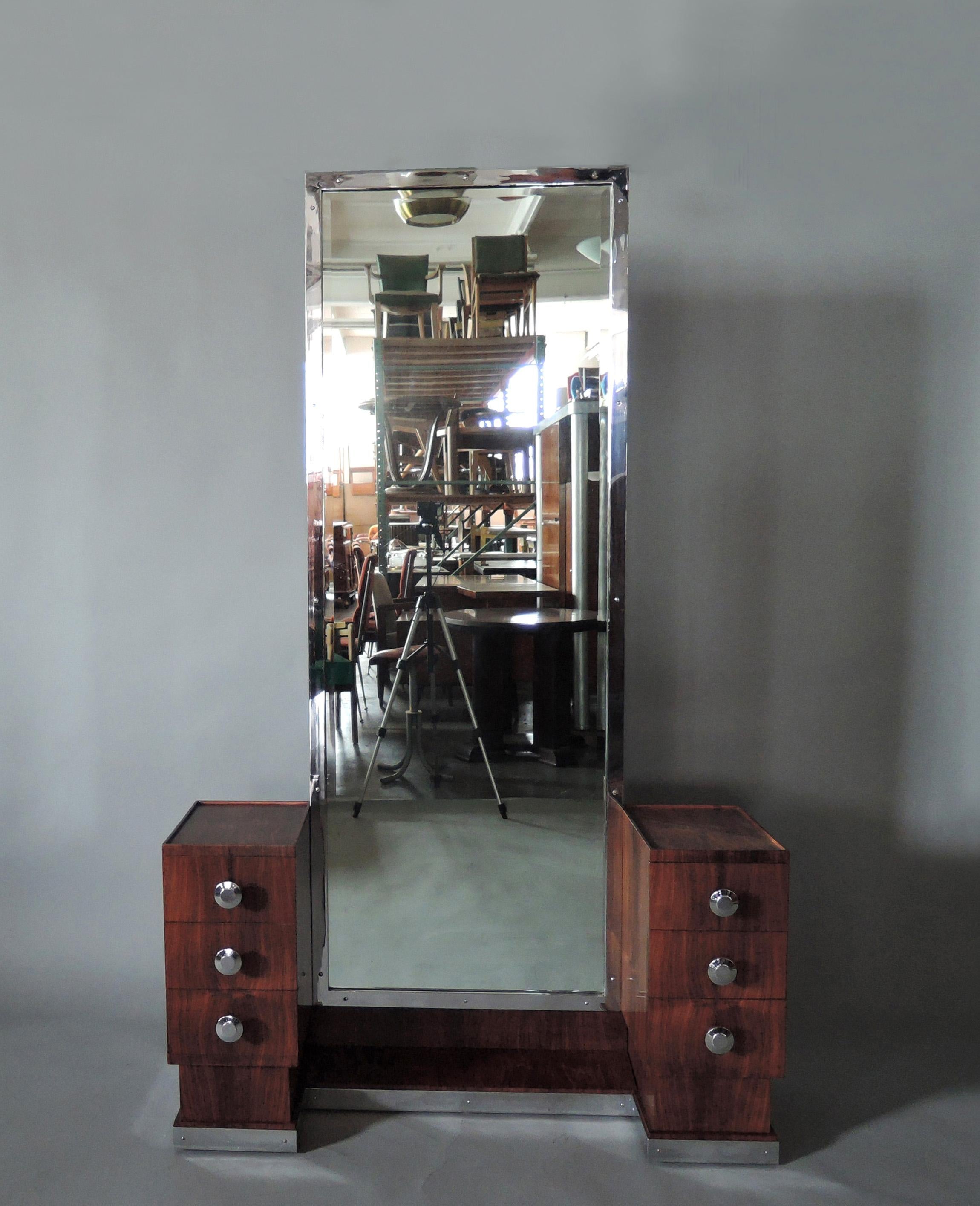 Une belle psyché / vanité en bois des années 1930 avec six tiroirs, un tiroir secret, un miroir encadré de chrome, et une plinthe et des boutons chromés. Le dos de la pièce est également plaqué, de sorte qu'elle pourrait être placée au milieu d'une