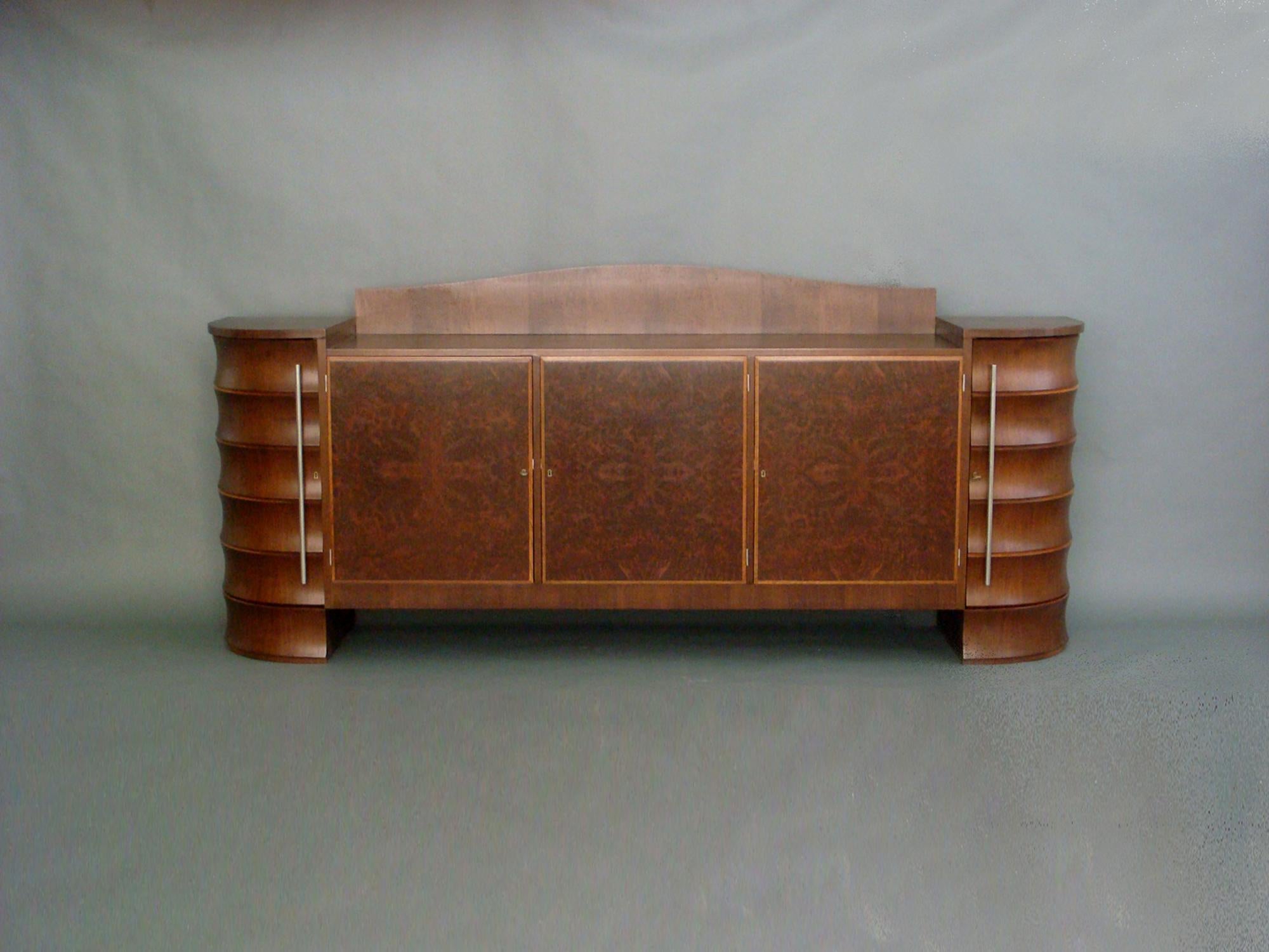 Fine French Art Deco walnut and burled walnut sideboard by Rene Prou in collaboration with Albert Guenot.
3 central doors in burled walnut et 2 curved side doors with vertical chrome pulls. 3 interior drawers.
Documented.