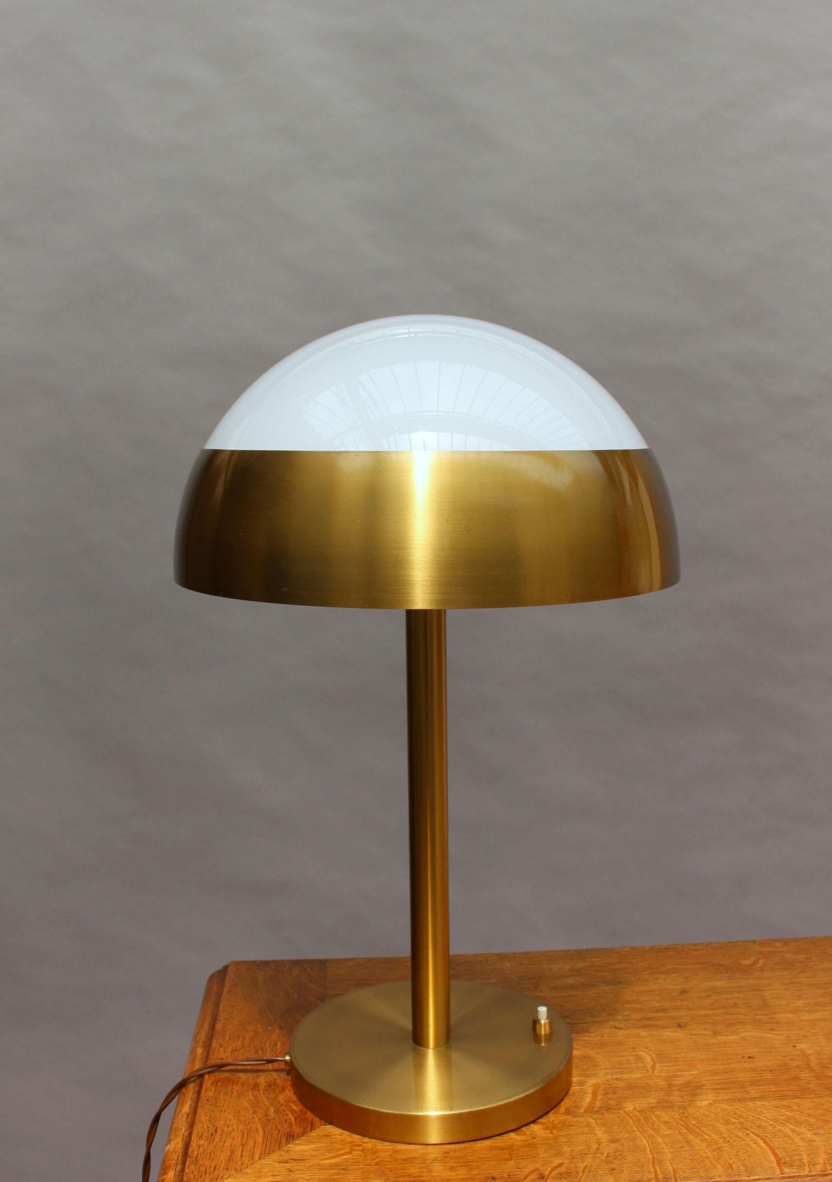With a bronze base that supports a white opaline shade.
 