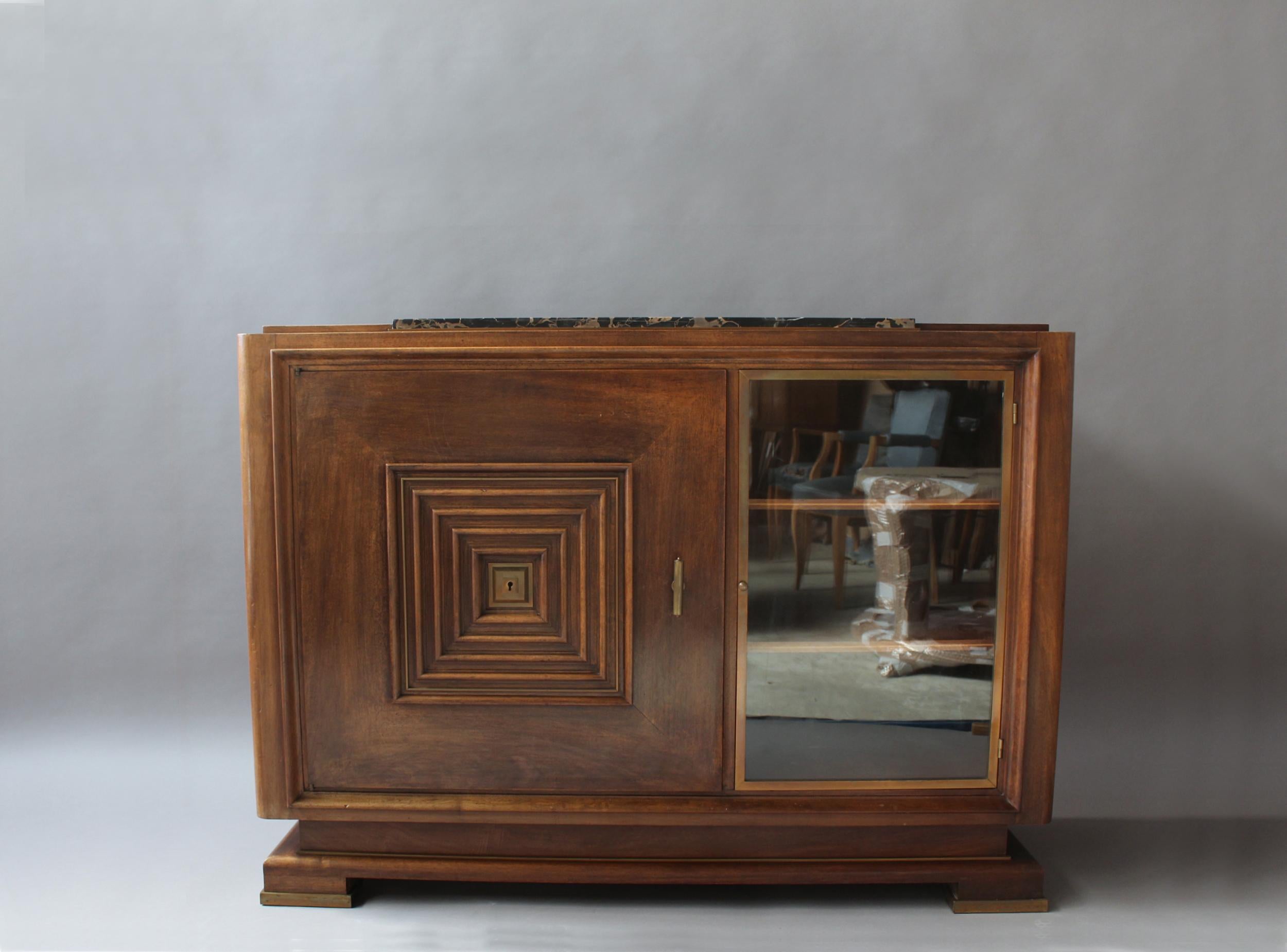 In walnut, with an insert black Portoro marble top, a bronze framed glass vitrine door and other bronze details.