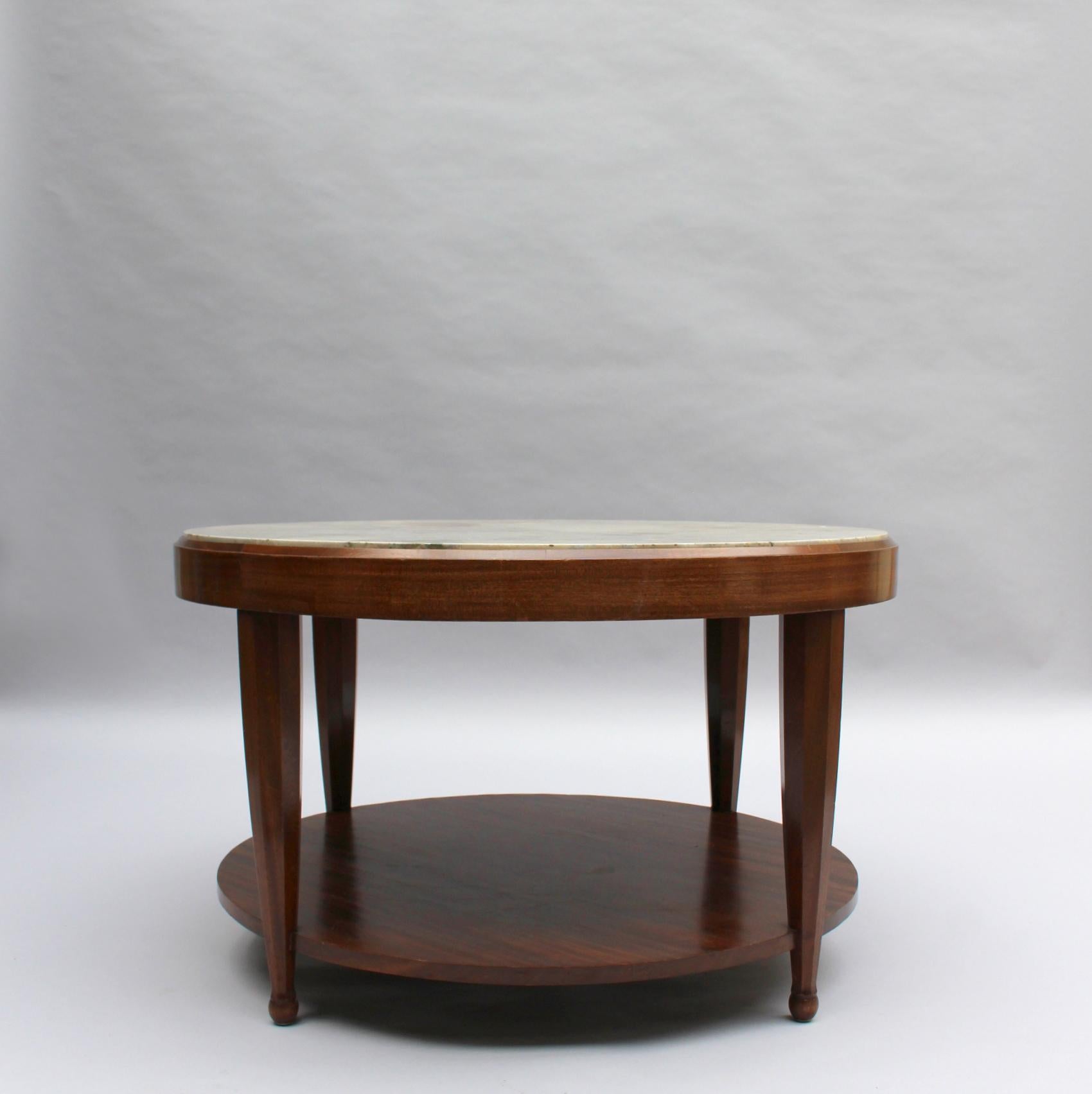 A fine French Art Deco round side table with a four leg mahogany base and a marble top