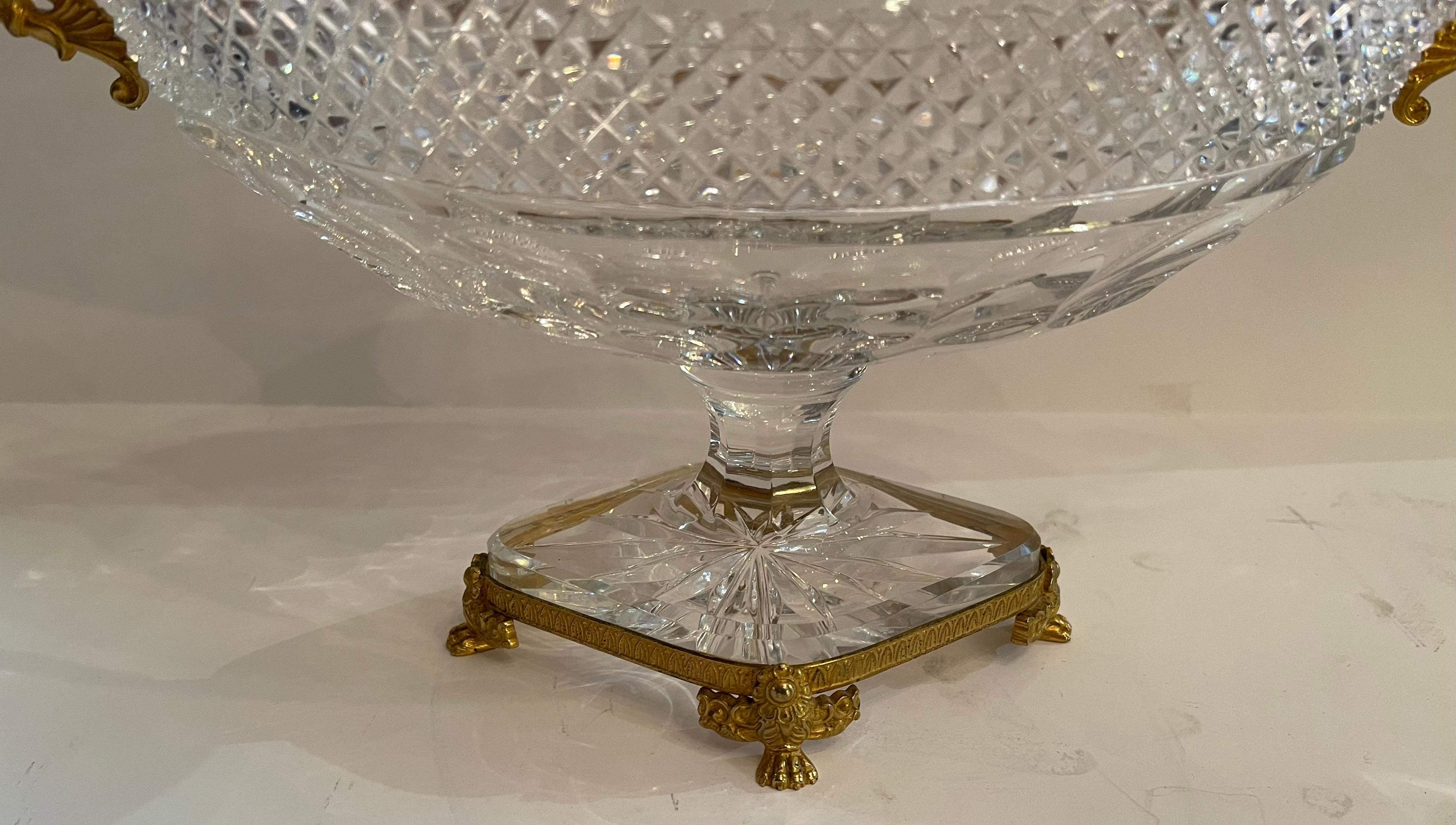 A fine French Baccarat style ormolu bronze paw foot and handle with diamond cut crystal oval centerpiece.