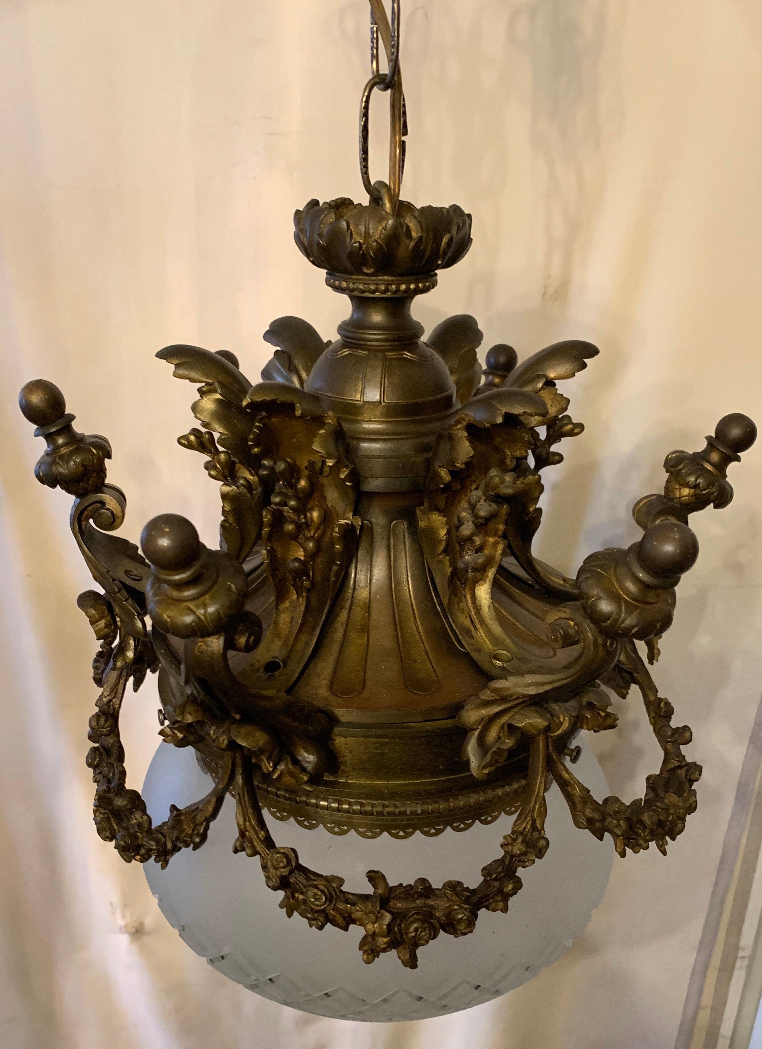 A fine French bronze filigree swag with bow details encasing an etched frosted glass globe pendant with an Edison light rewired and ready to install with canopy and mounting hardware.