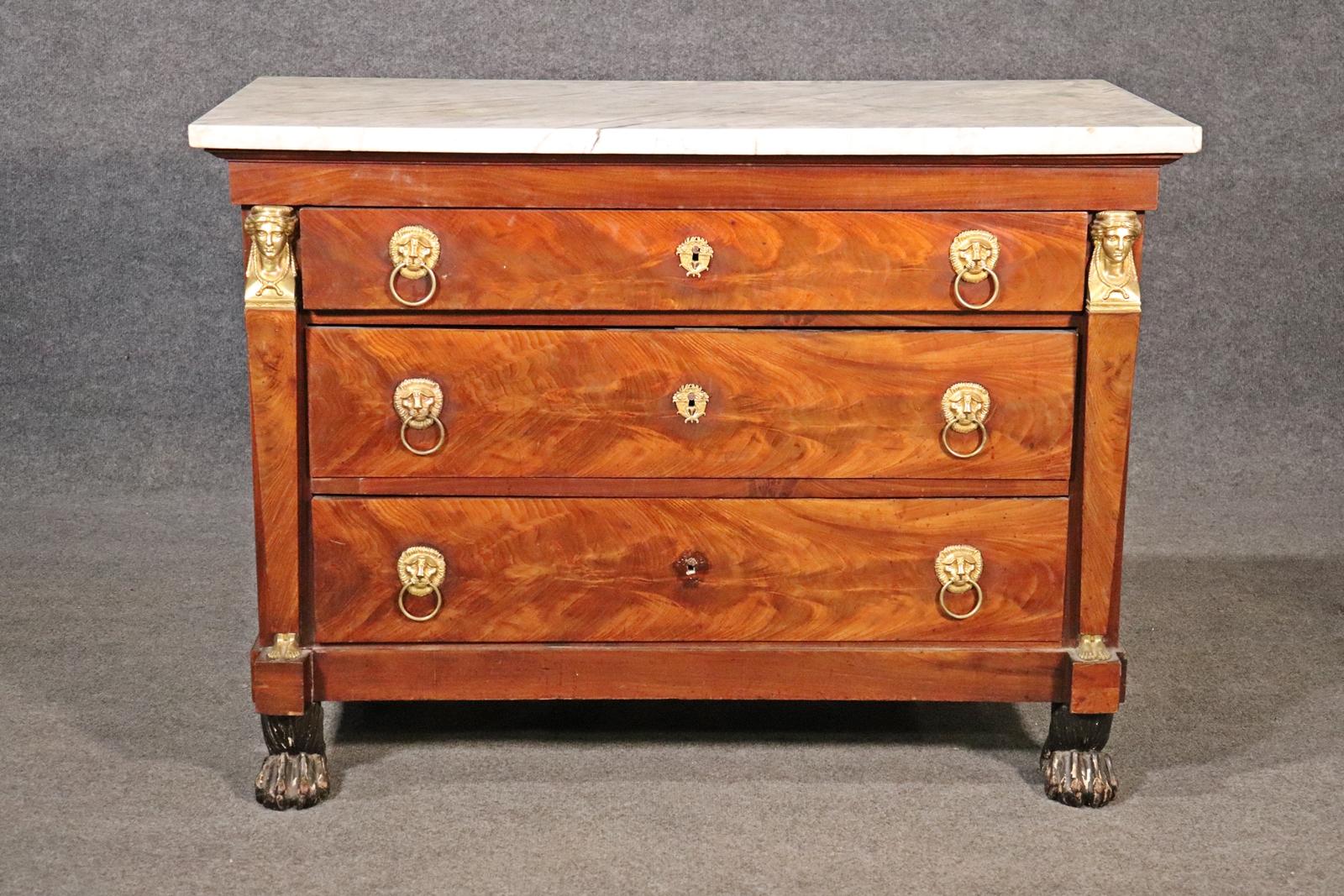 Absolutely gorgeous design and elements. Look at the condition of the wood. Notice the beautiful Marble top. Flame Mahogany. Brass figural accents. Claw foot. 3 drawers. Measures: 34