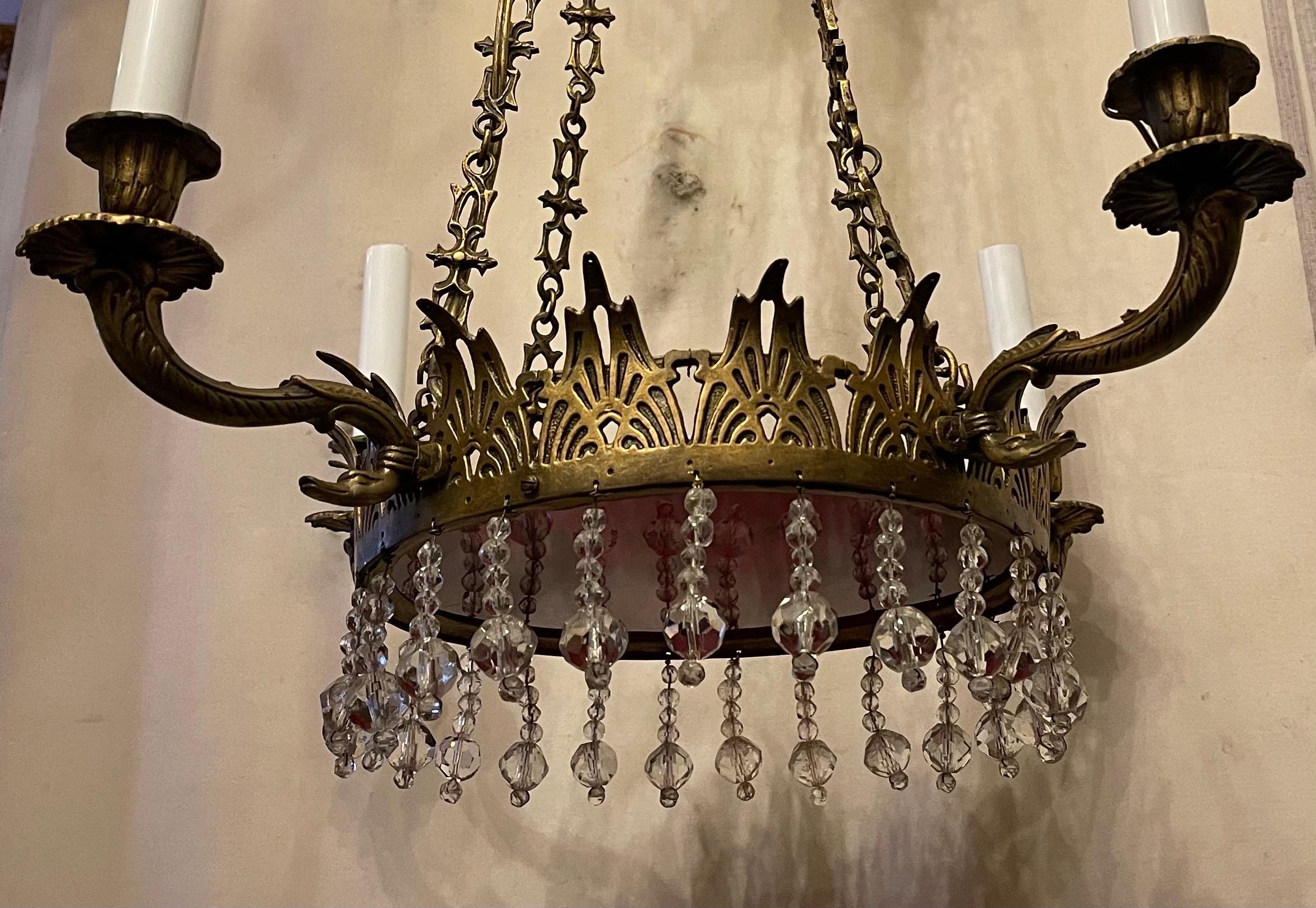 A fine French Empire / neoclassical style gilt bronze and red glass centerpiece with crystal drop Baltic chandelier having four swan arms rewired and accompanied by Cain canopy and mounting hardware.

This chandeliers height may be adjusted by
