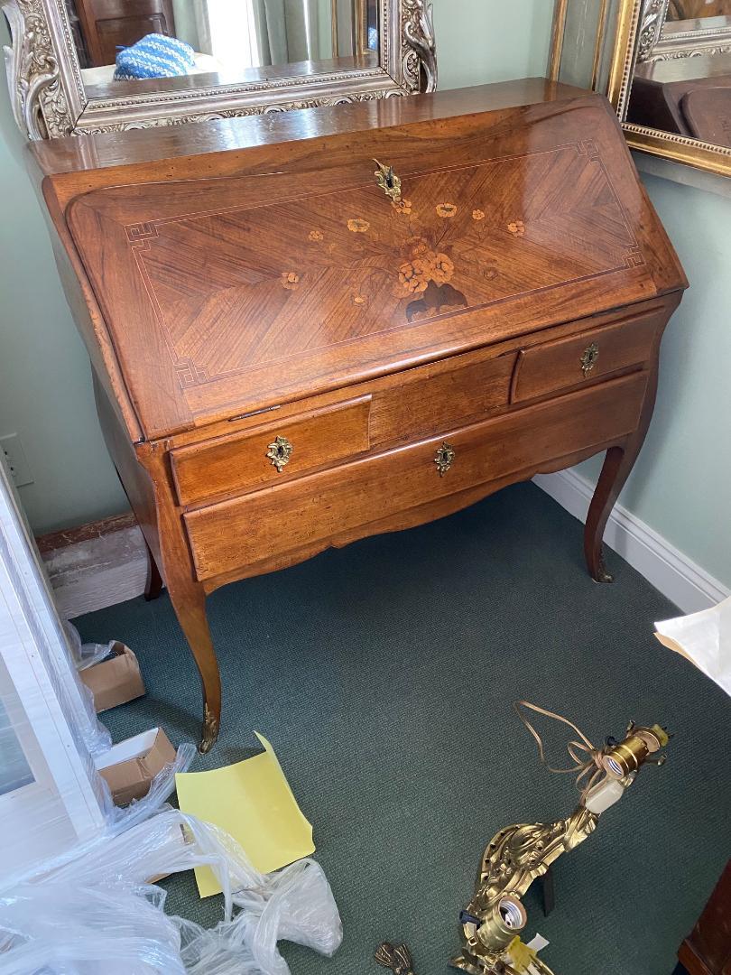 Fine and elegant French Louis XV Bureau D'Os Dane in walnut adorned sparsely with floral marquetry inlay to its fall front top above three drawers finishing on cabriole legs and bronze sabots; the two top drawers are concaved flattering the