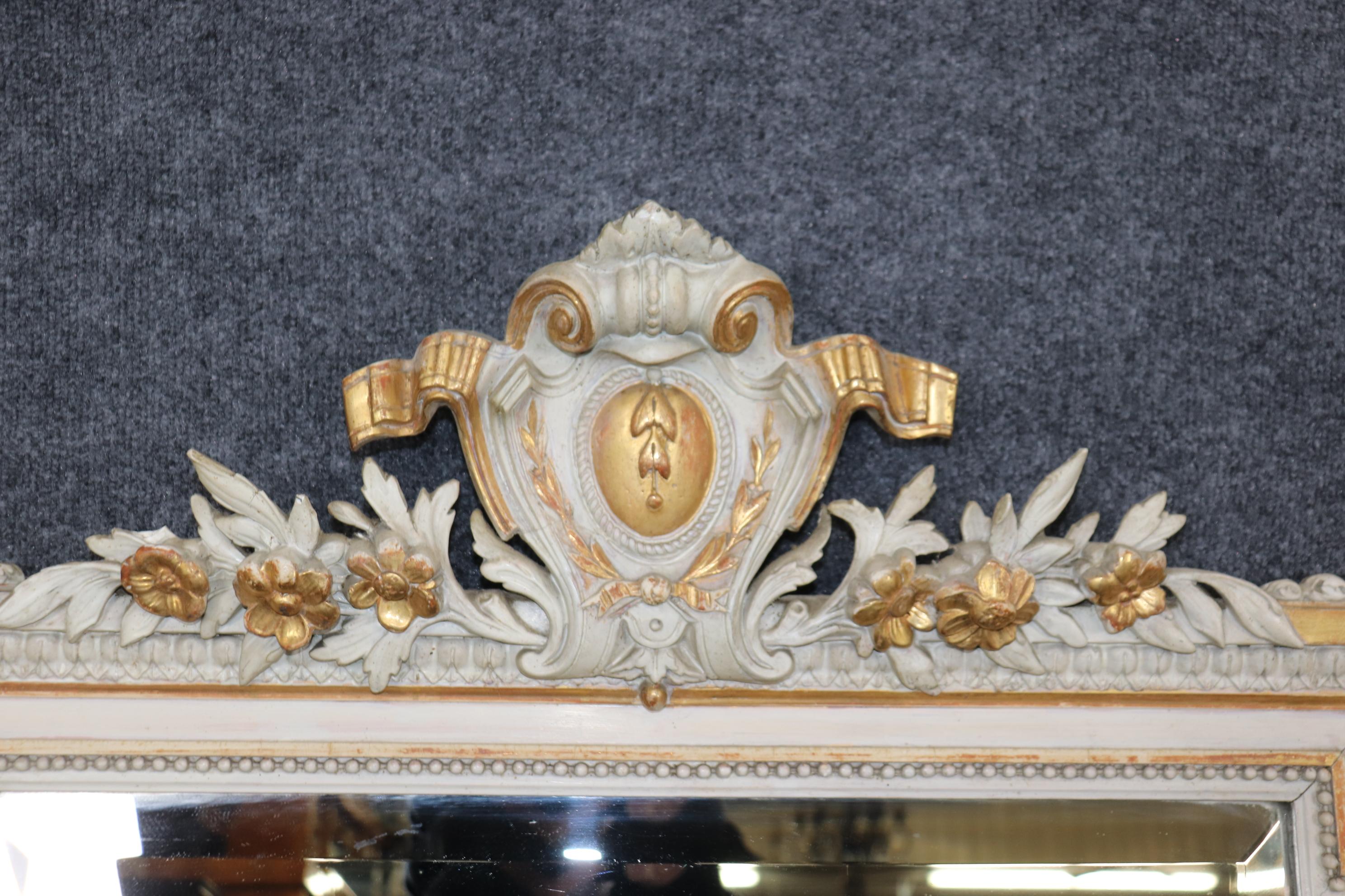 This is a beautiful gray painted and genuine gold gilded carved Louis XV mirror. The mirror can be used as a mantle (mantel) or buffet mirror. The mirror features gorgeous carved details and beautiful genuine gold leaf over an Italian red clay bole