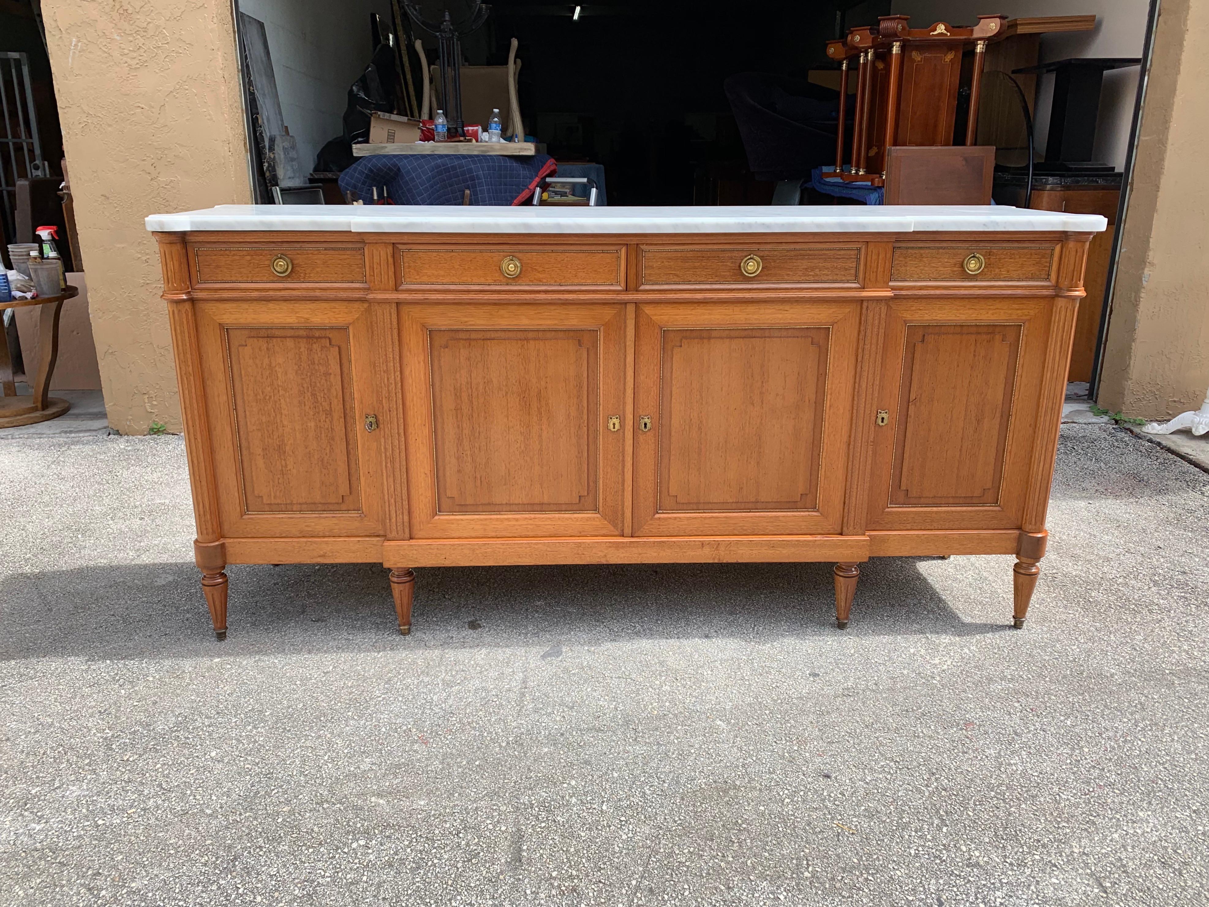 Fine French antique Louis XVI style sideboard or buffet made of mahogany with a beautiful Carrara marble top, the mahogany wood has been finished with a French polished high luster inside and outside, the buffet has 4 doors and 4 drawers with all 6