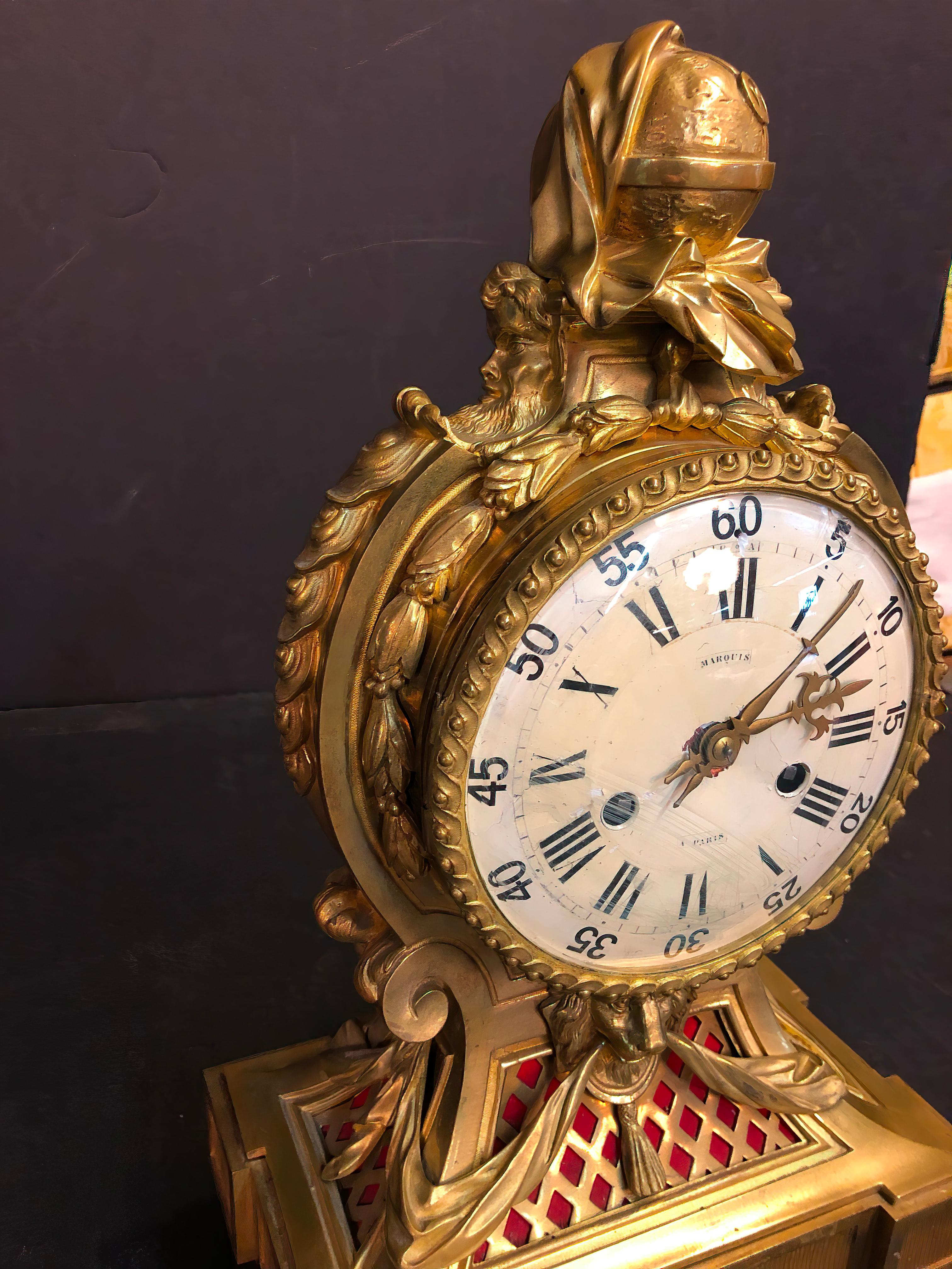 Un raffinato e raro orologio da camino in bronzo Luigi XVI del XIX secolo, realizzato da Marquis a Paris. Il meraviglioso orologio presenta elaborate decorazioni in bronzo con maschere, ghirlande di foglie, un quadrante smaltato bianco guilloché,