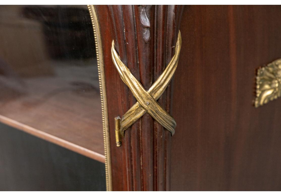A very well made Sinuous French Vitrine Cabinet  topped with a Colorful veined Marble in Pinks, Browns and White. The Cabinet has French type motifs of Bundled Reed corner  supports topped with Shell carvings and terminating in a bold Hoof Foot.