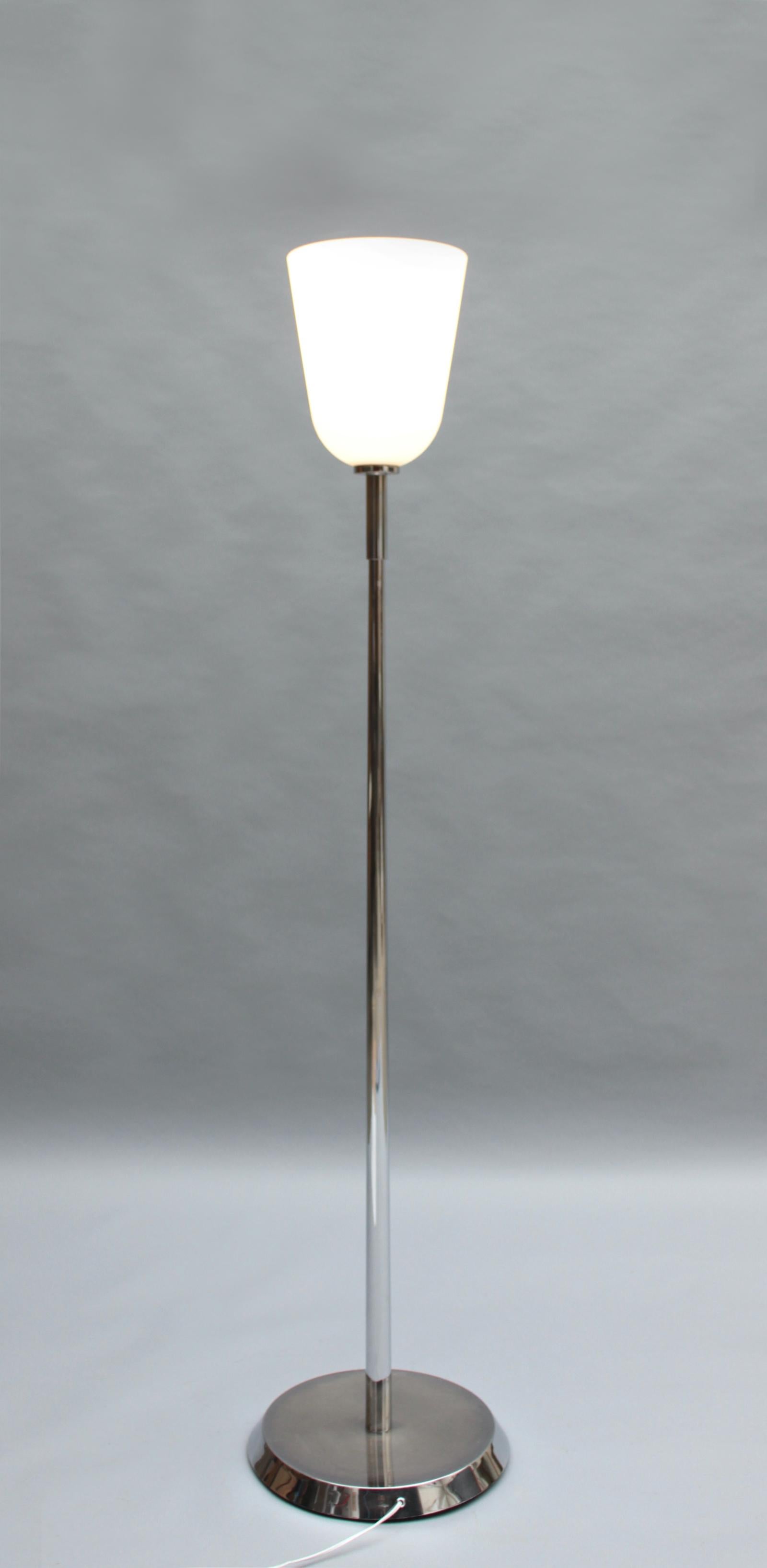 With a thick glass and chrome bowl shade mounted on a chrome stem and round base.