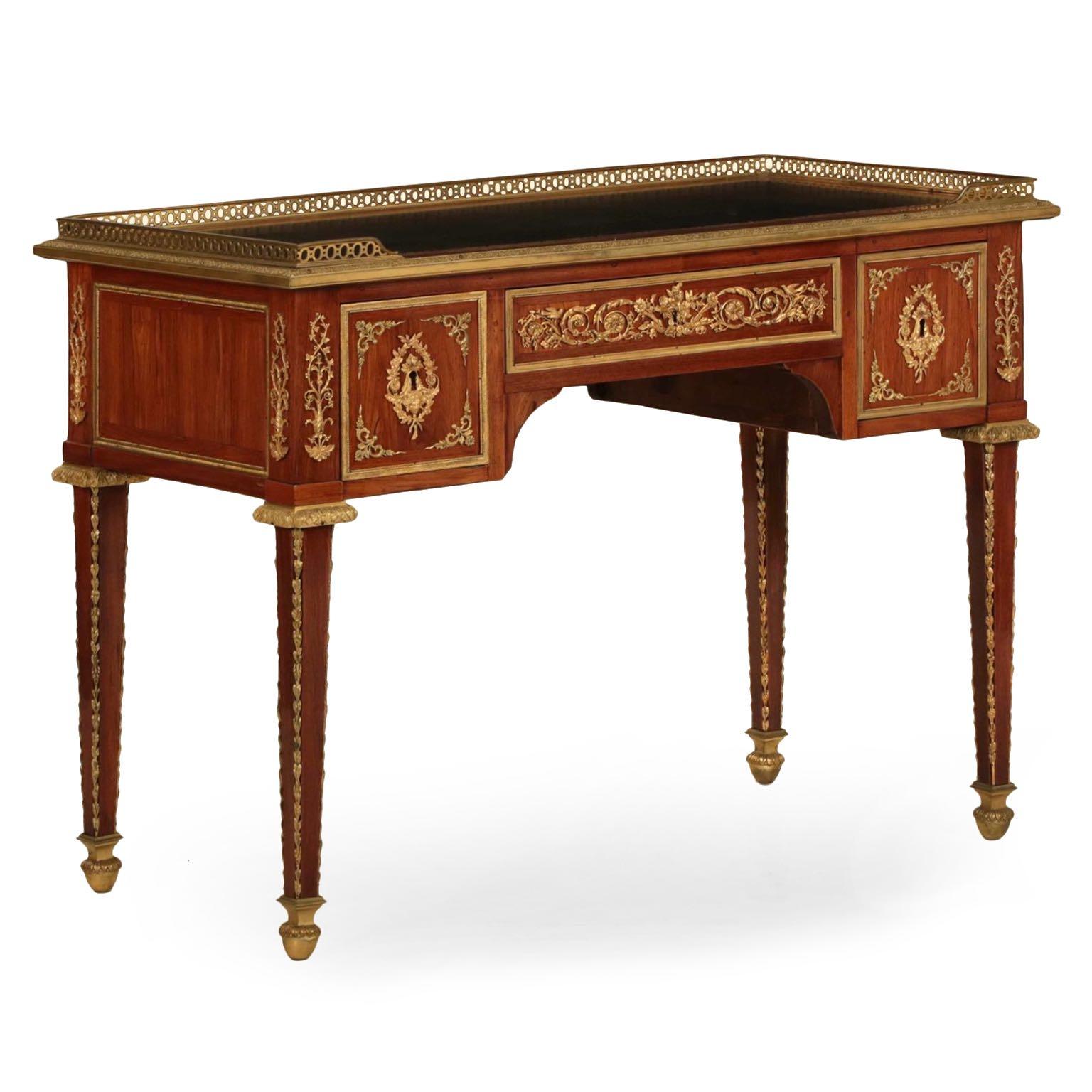 This very fine French writing desk is inordinately rich the rosewood veneers utilized to dress the facade are most dramatic and are beautifully polished. The gilded bronze mounts contrast against the warm reds of the surface, each exquisitely