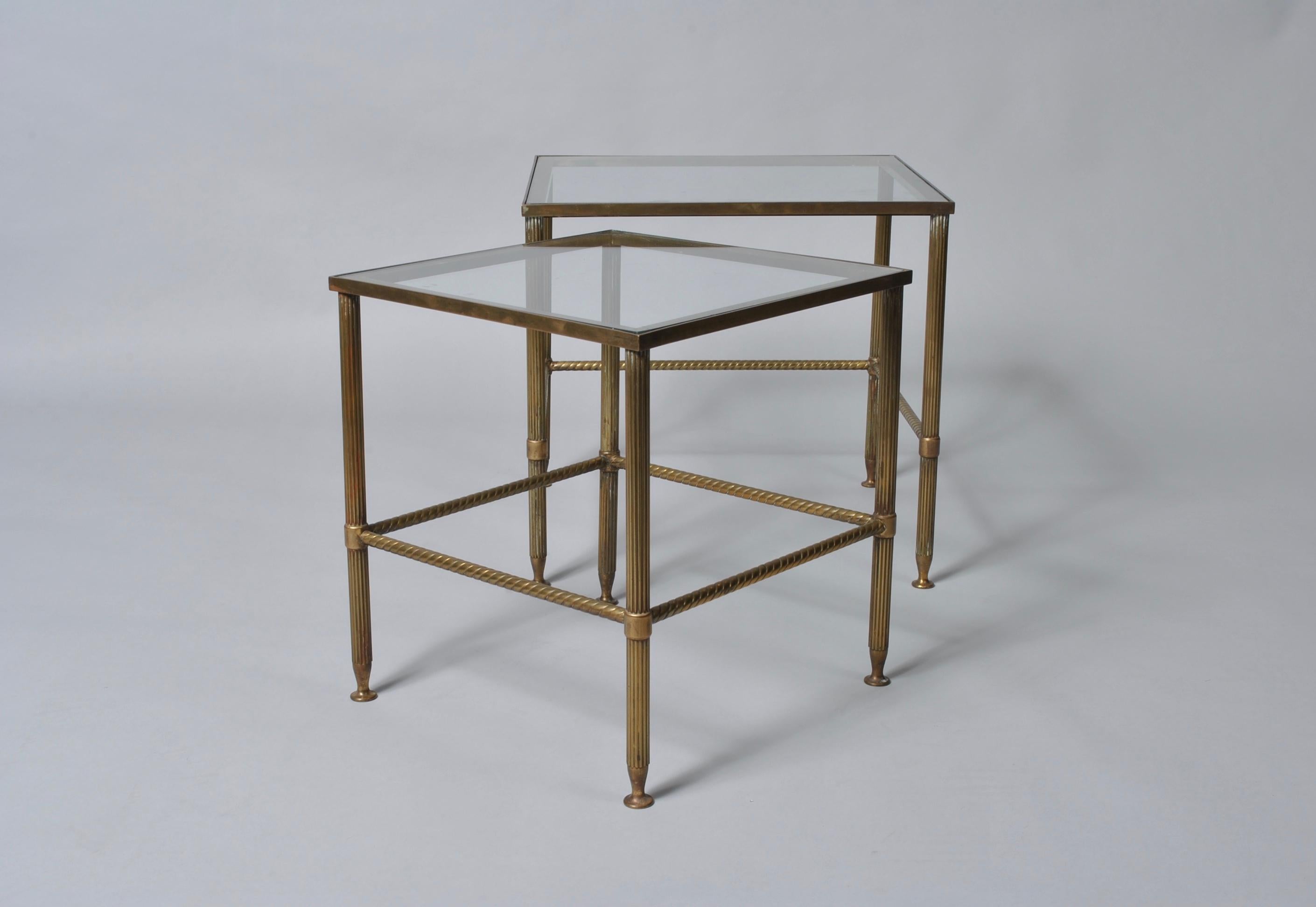 A set of very fine quality midcentury French Maison nesting tables. Produced in France, circa 1950. Superb aged patination to the brass roped and fluted frames. Classic, stylish and practical pieces.
      