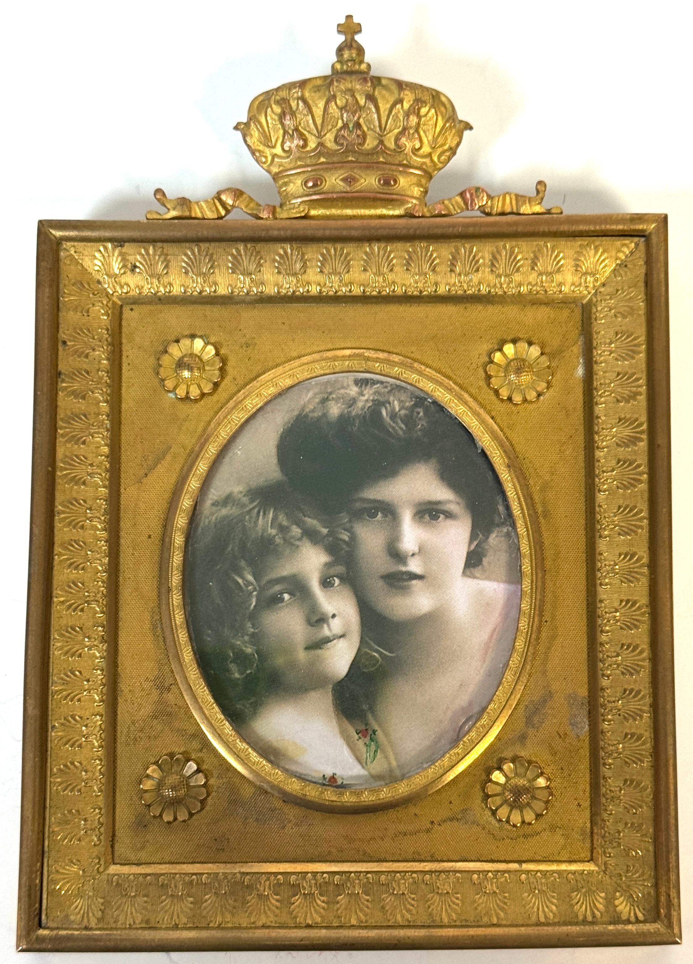 Cadre à couronne en bronze doré avec photographie teintée, vers 1890-1910

Cadre de portrait français en bronze doré richement détaillé, surmonté d'un fleuron royal et finement décoré à la manière néoclassique. Le cadre rectangulaire présente un