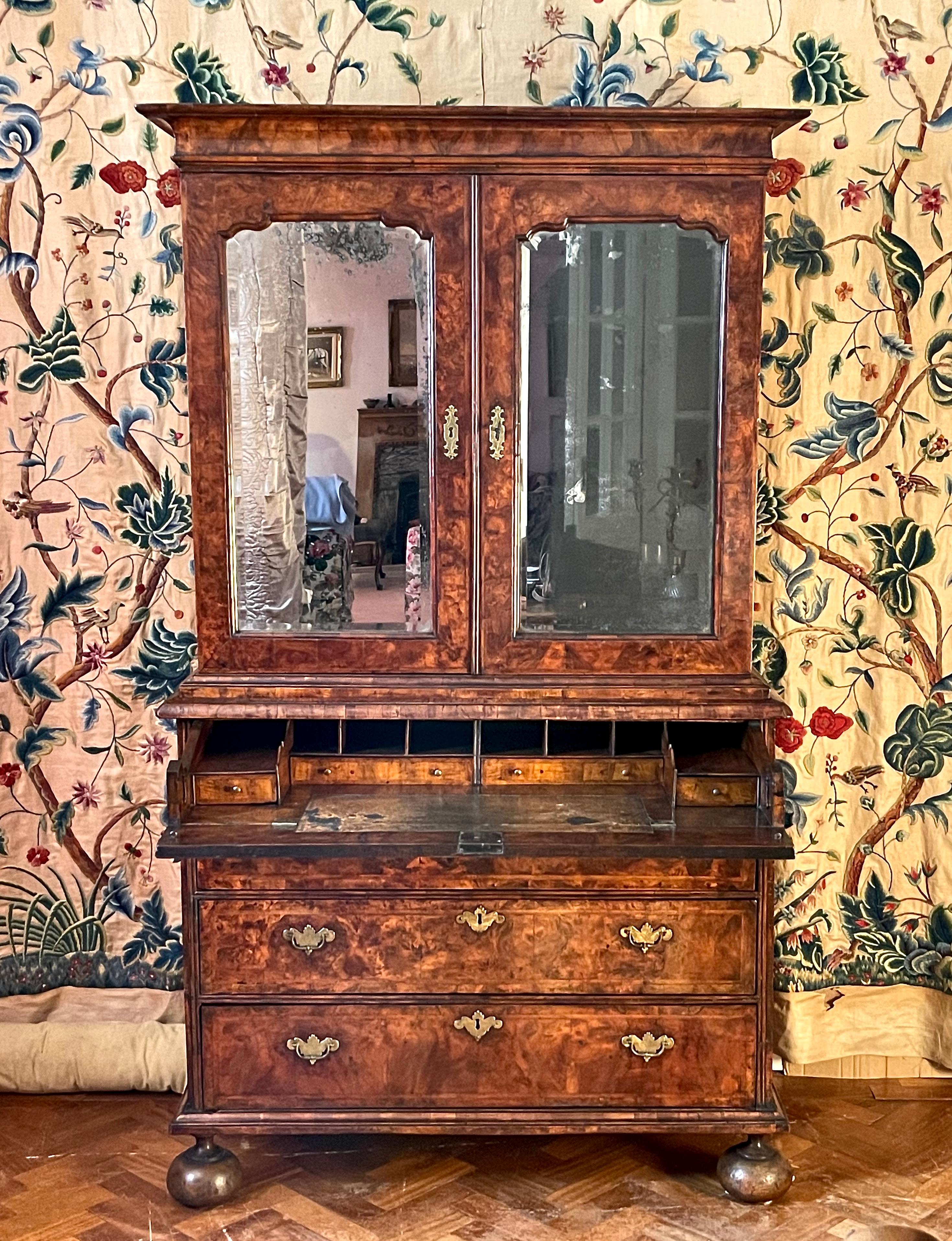 A fine English George I-period burr (burl) walnut secretaire cabinet.
Early-18th century, ca 1720.

The top section separates from the base and opens to reveal numerous fitted drawers, behind doors with original bevelled arched mirror plates.
The