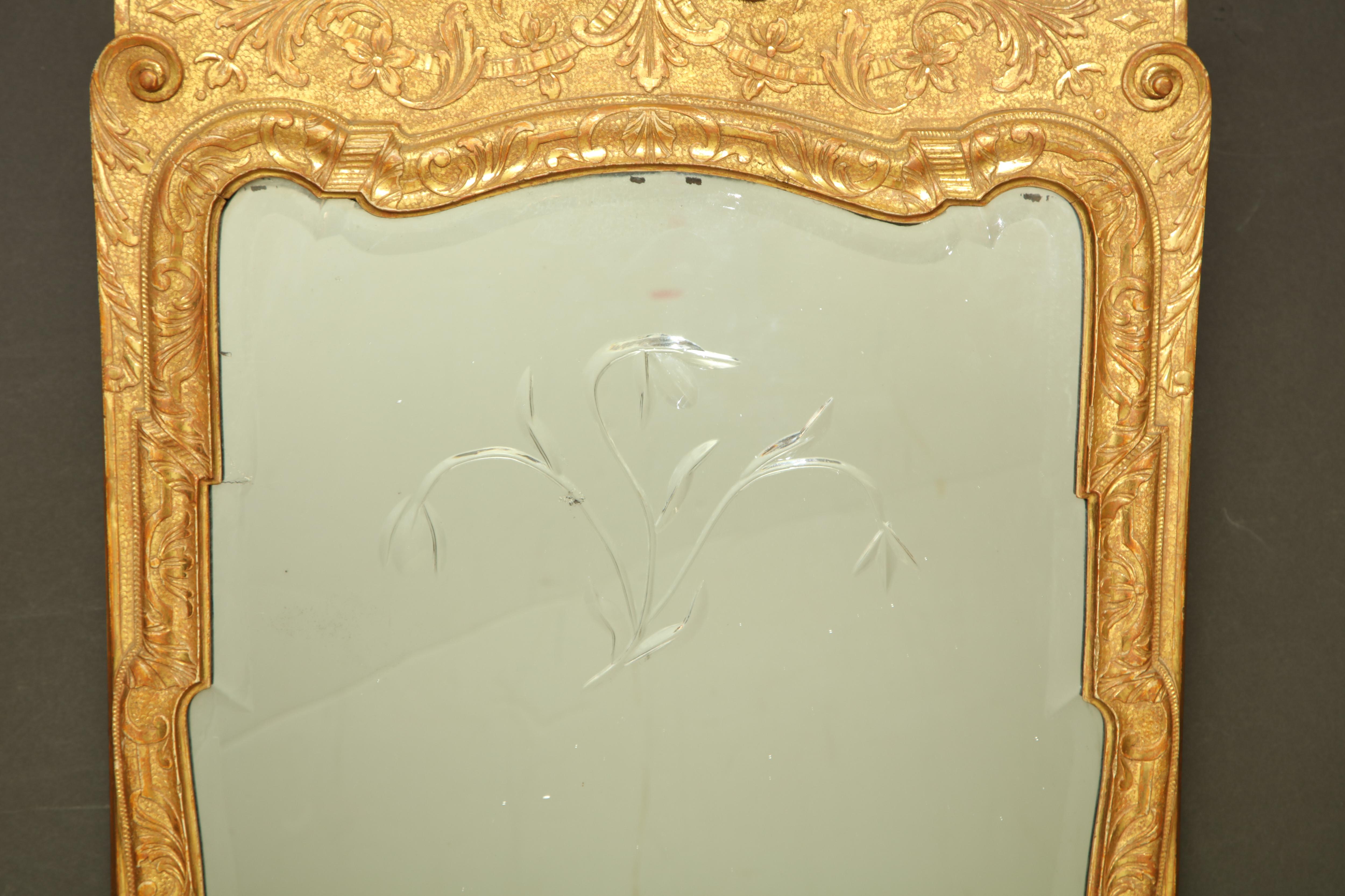 An exceptional and rare George I incised giltwood pier mirror with carved plume surmount and two-part beveled and cut glass mirror. 

England, circa 1730.
 
